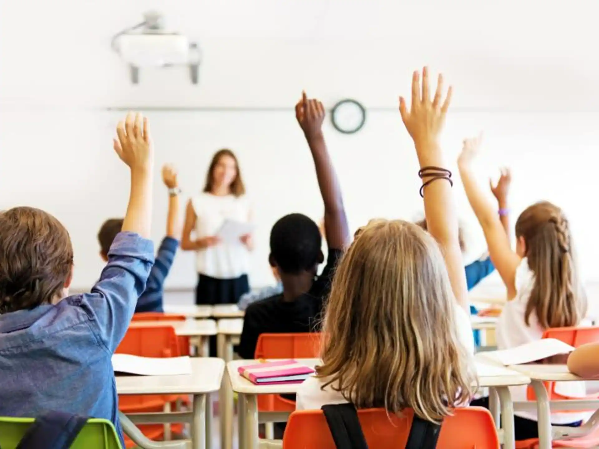 a group of children raising their hands