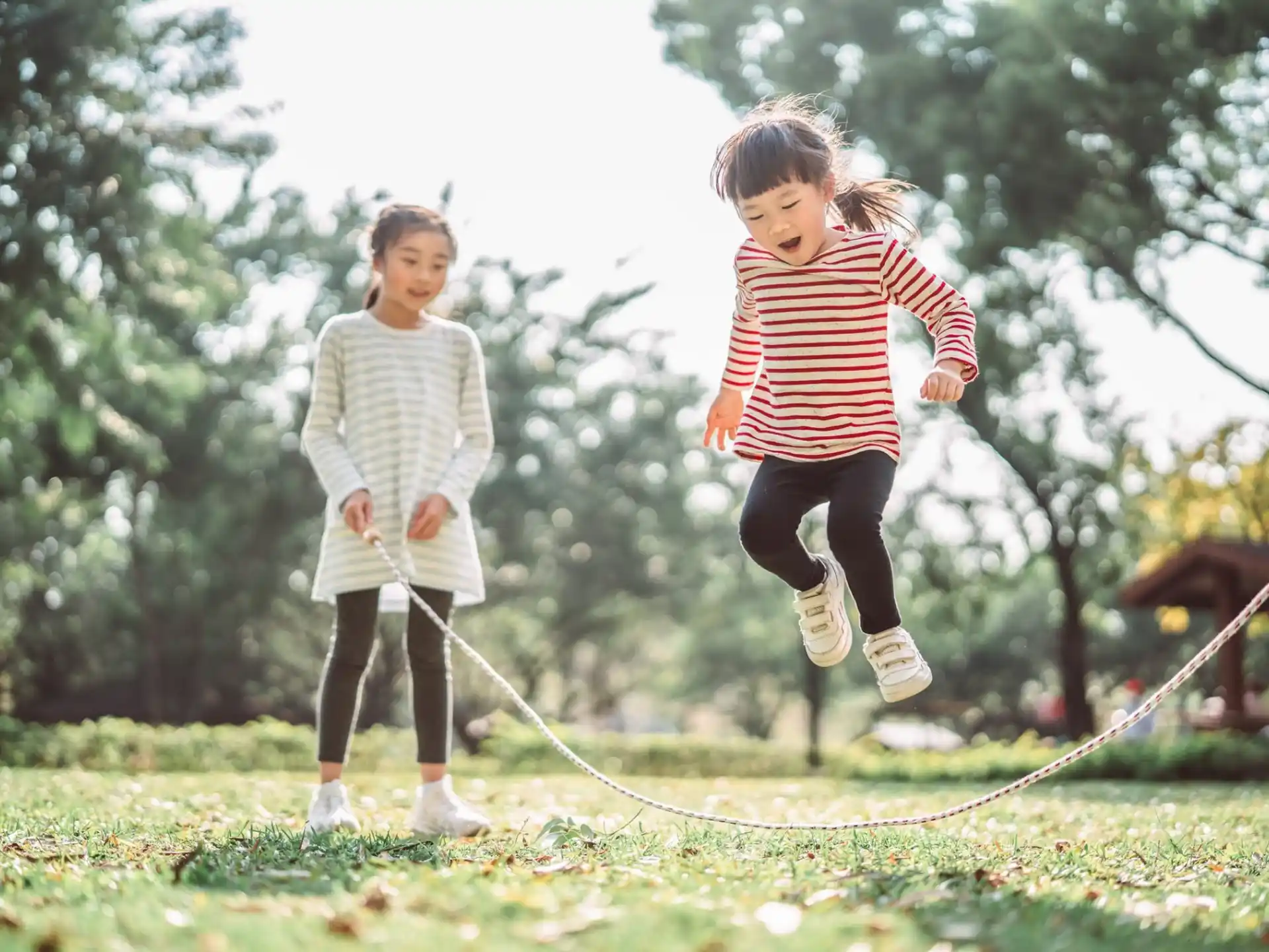 a couple of children running on a grass field