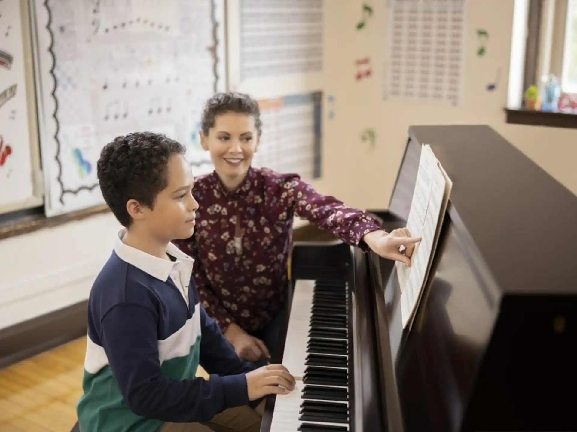 a person and a boy playing piano