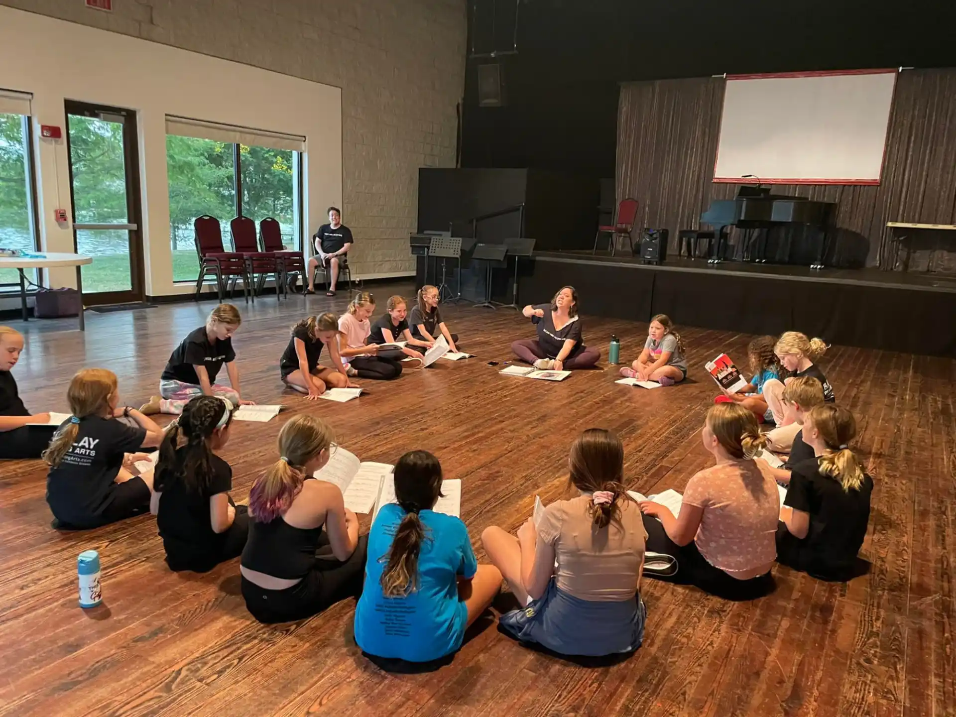 a group of people sitting on the floor in front of a stage