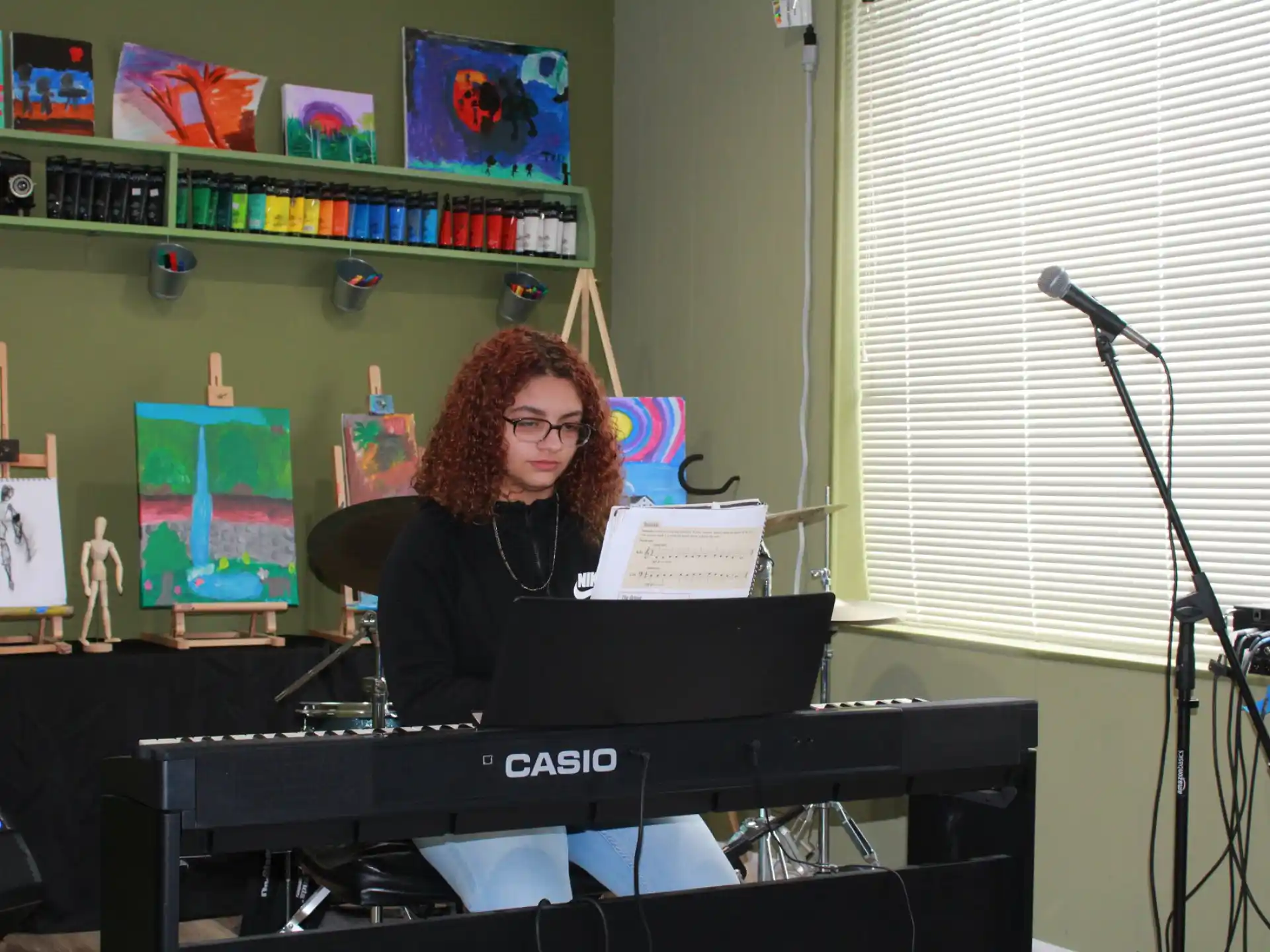 a person sitting at a desk with a microphone and a laptop