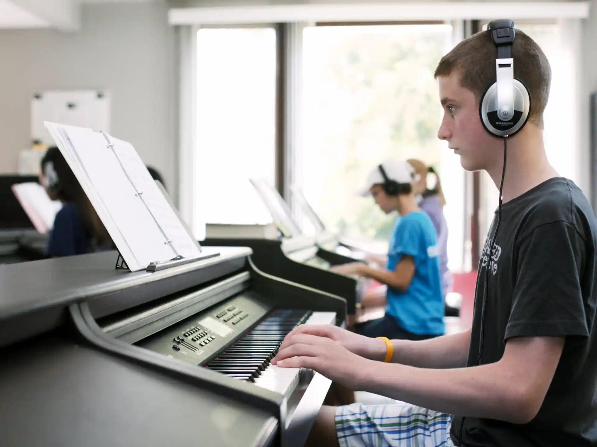 a man wearing headphones and playing a piano
