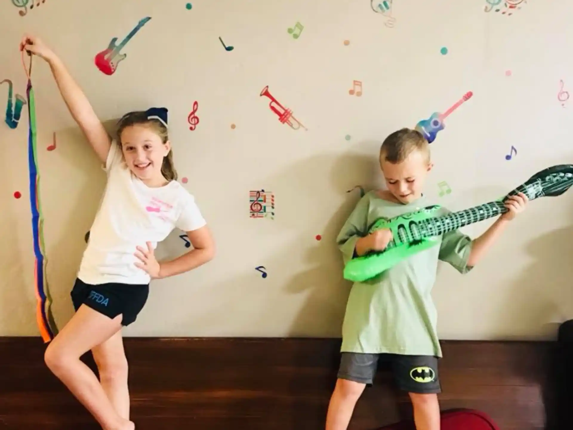 a boy and girl playing with a toy sword