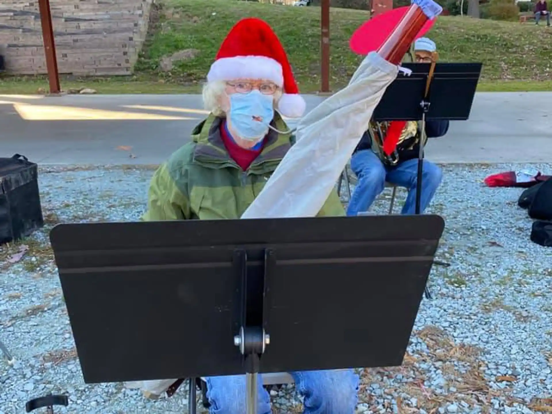 a person in a santa hat and scarf holding a large black object