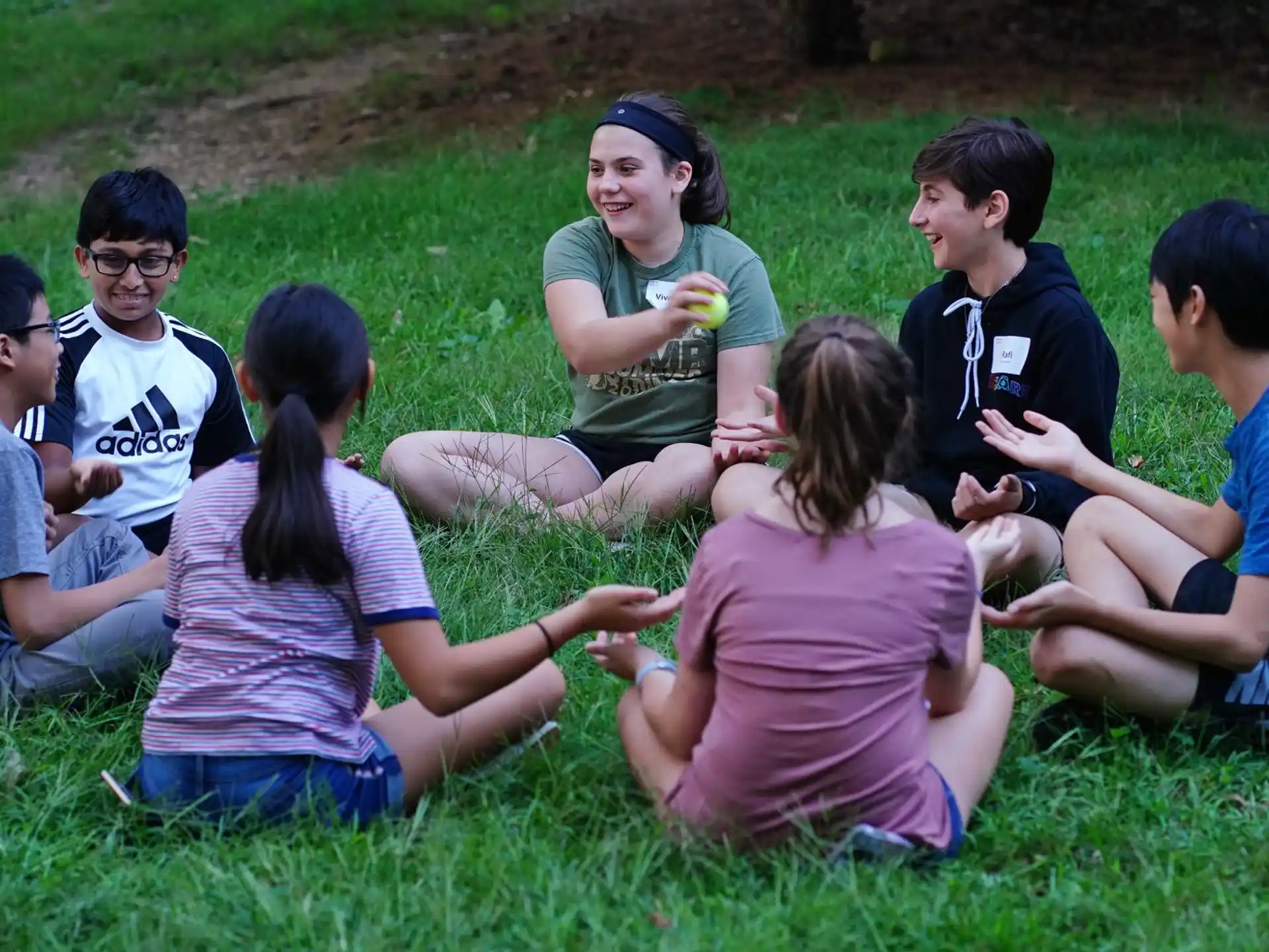 a group of people sitting on the grass