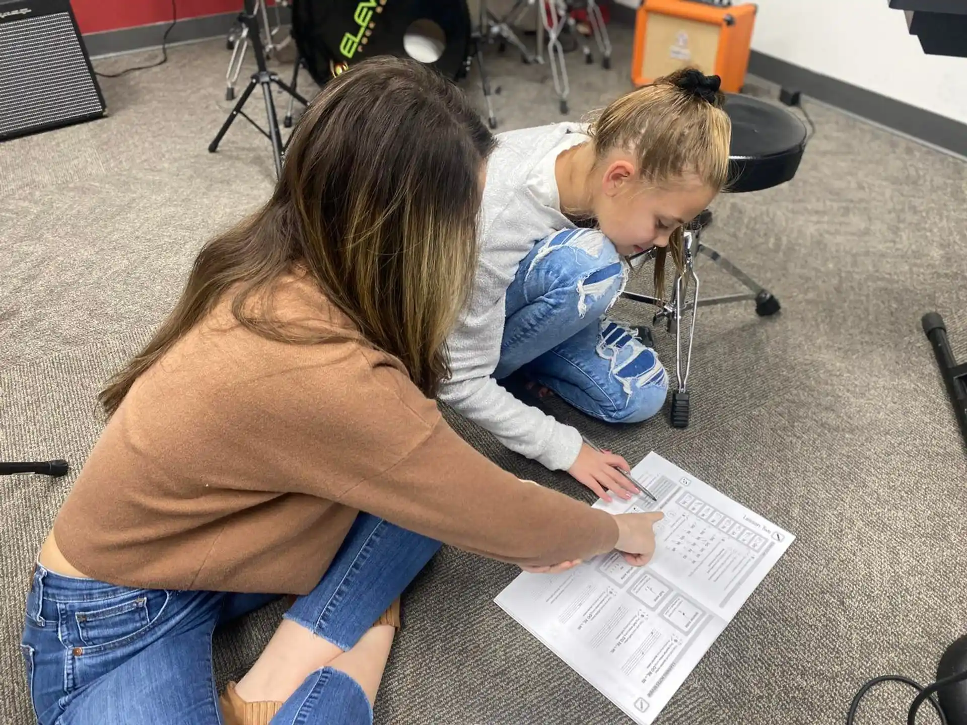 a person and a boy looking at a piece of paper