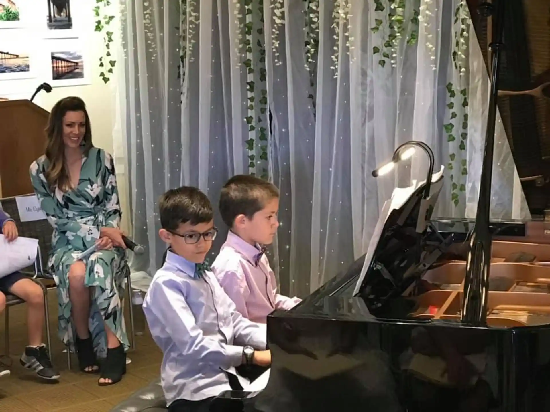 a group of people sitting at a piano