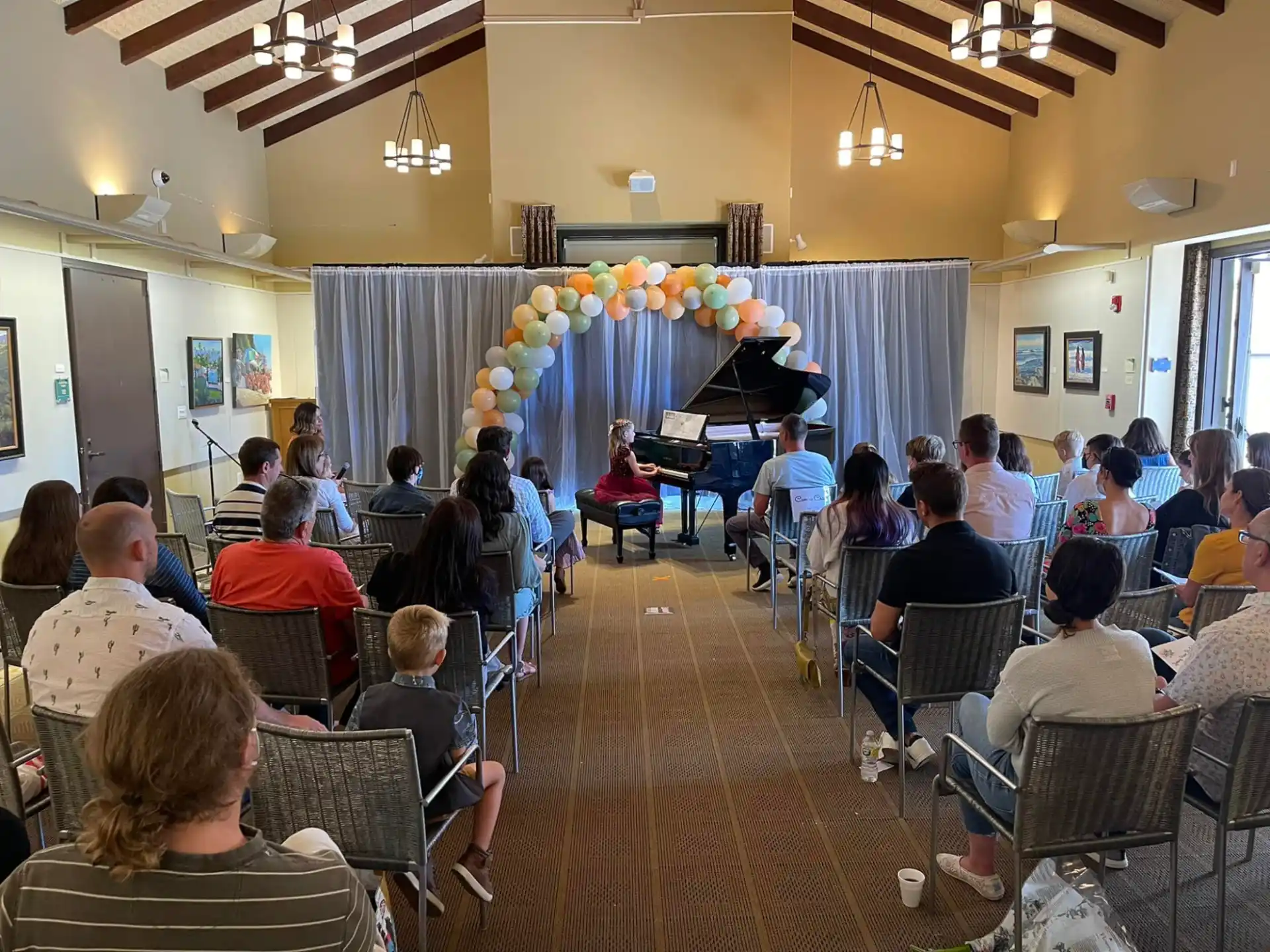 a group of people sitting in a room with balloons