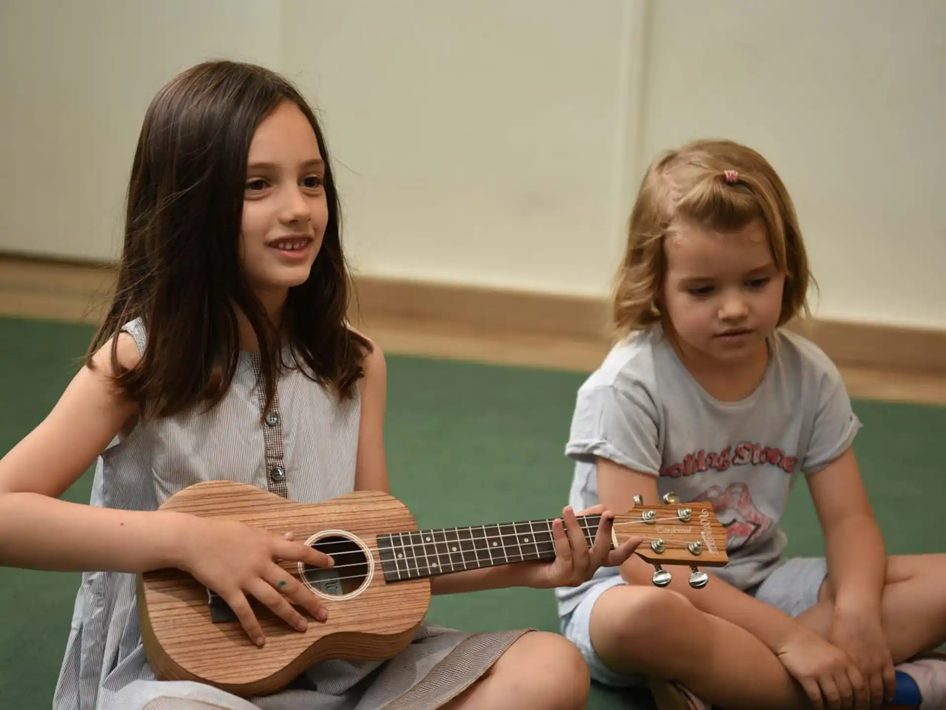 a person and a child playing guitar