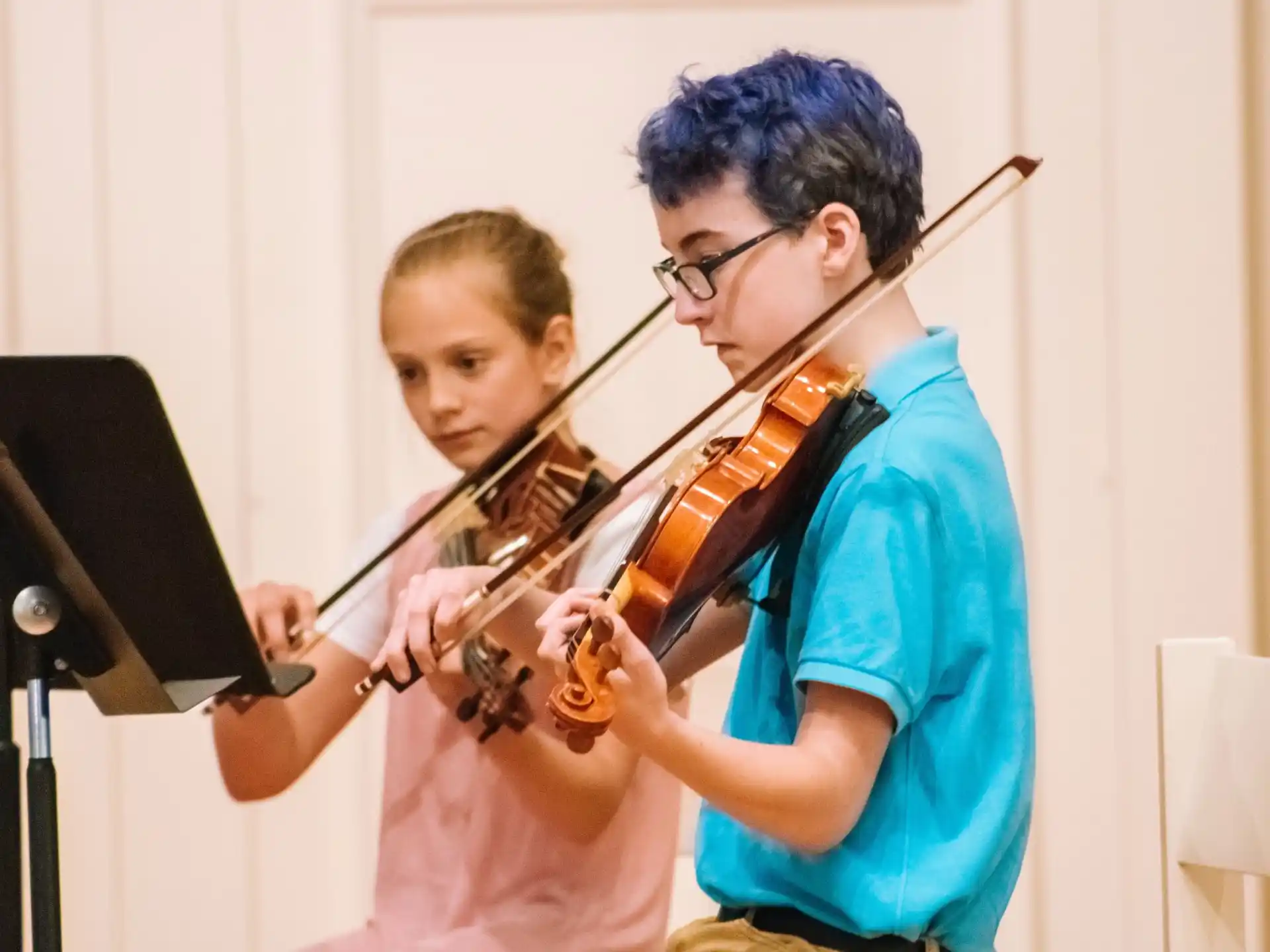 a man playing a violin next to a woman playing a violin