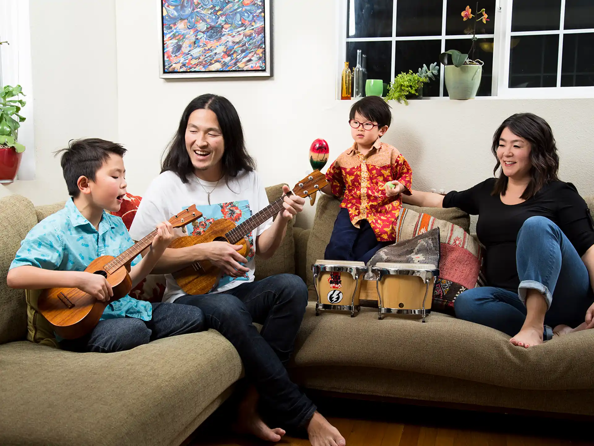 a group of people sitting on a couch playing guitars
