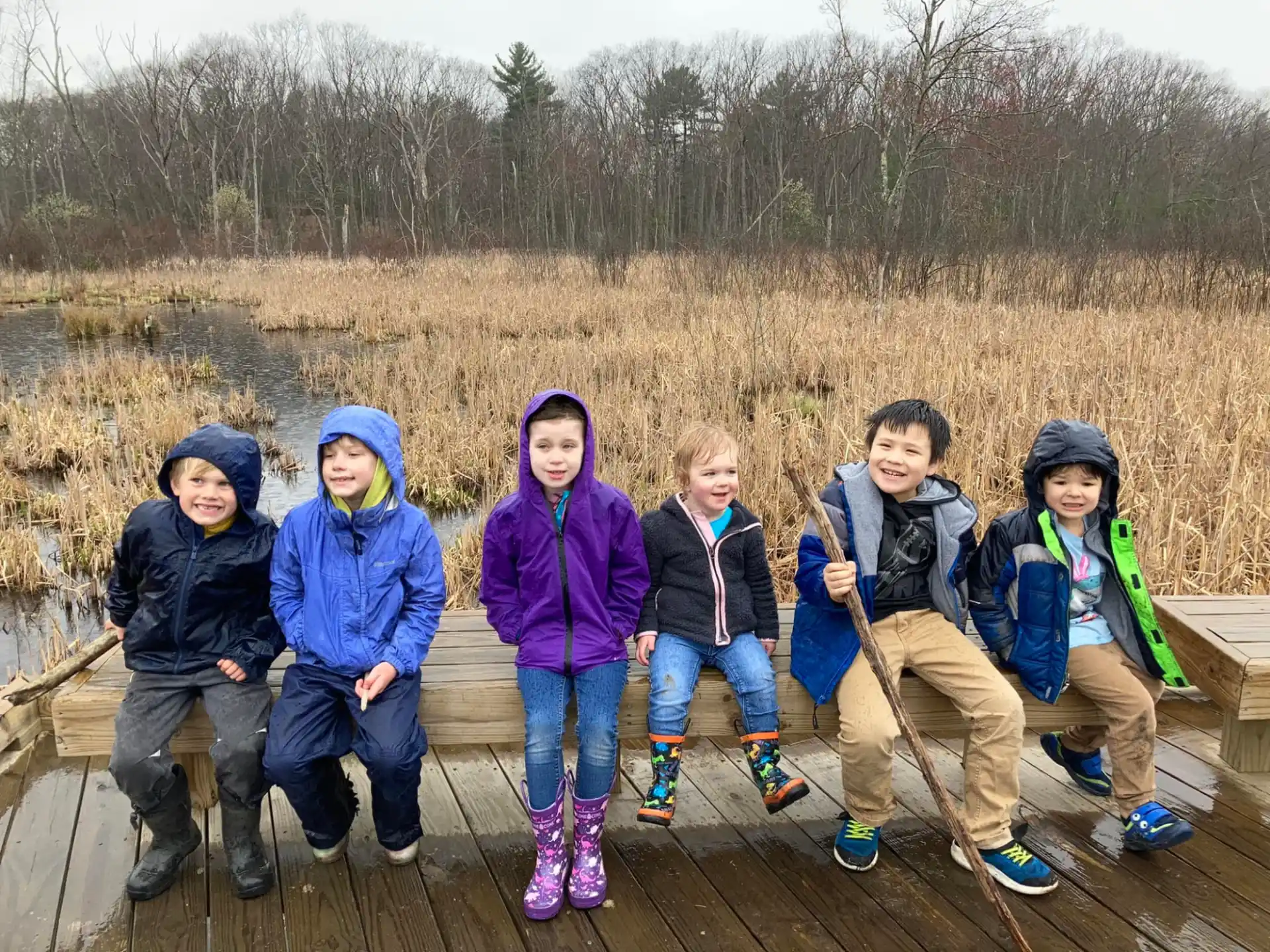 a group of people sitting on a log posing for the camera