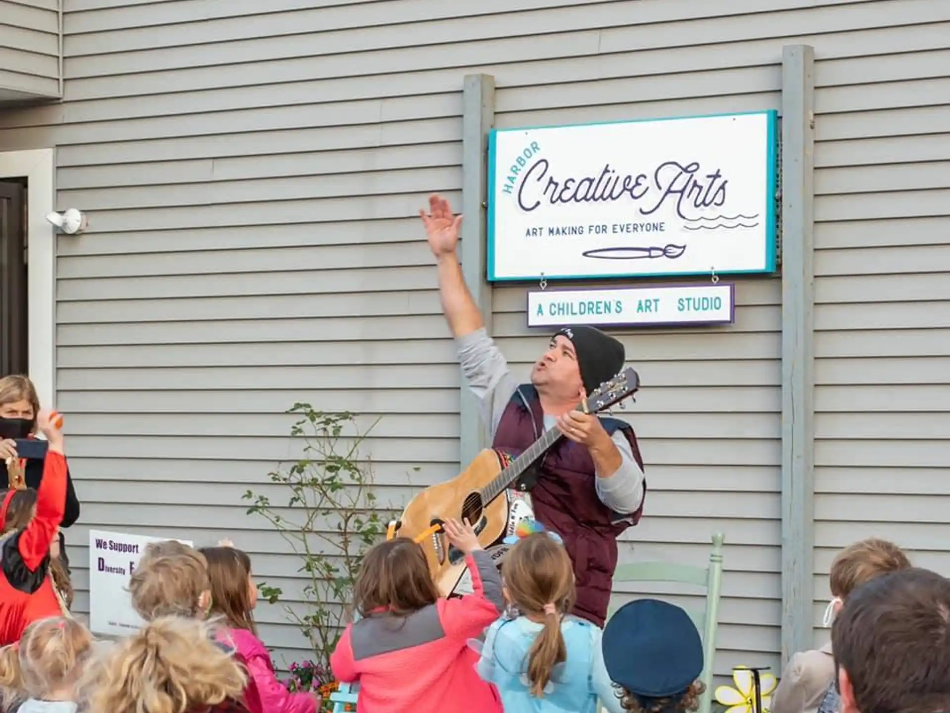a person playing a guitar in front of a crowd of people