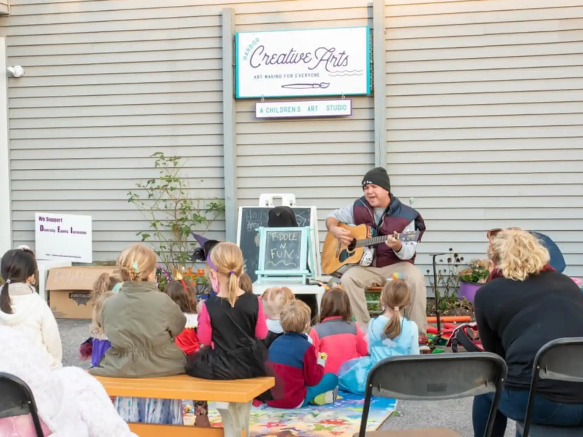 a woman playing guitar in front of a group of people