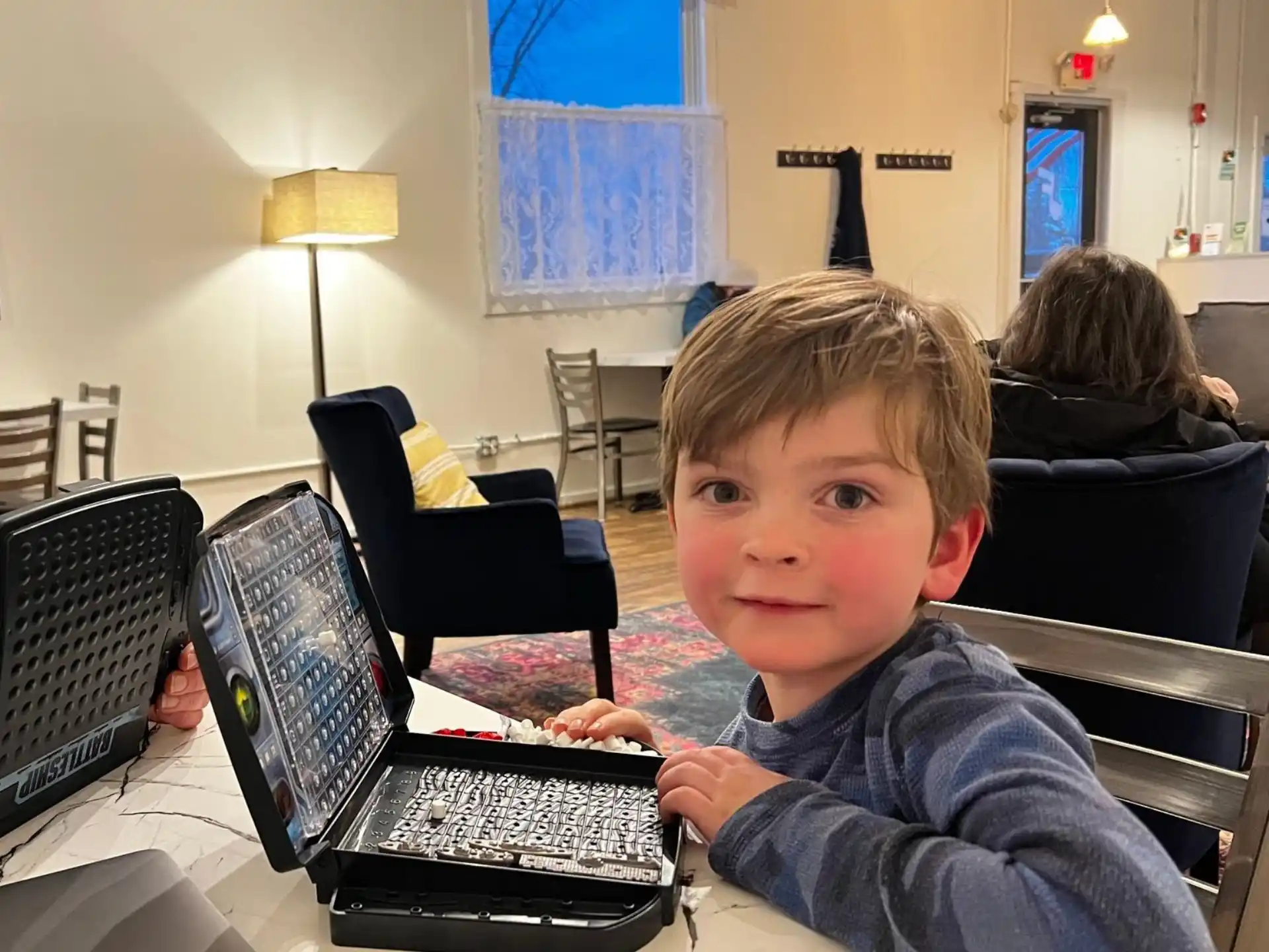 a boy sitting at a desk with a laptop