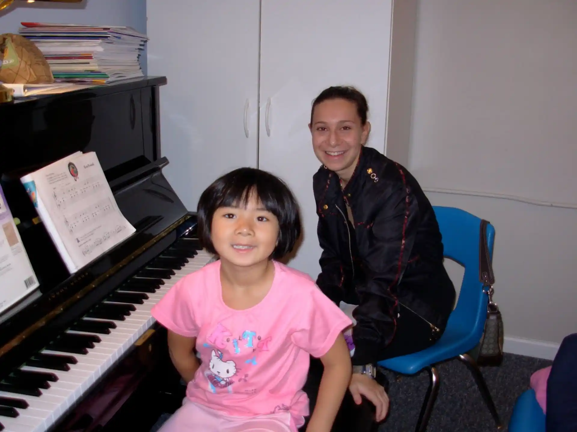 a person and a girl posing for a picture in front of a piano