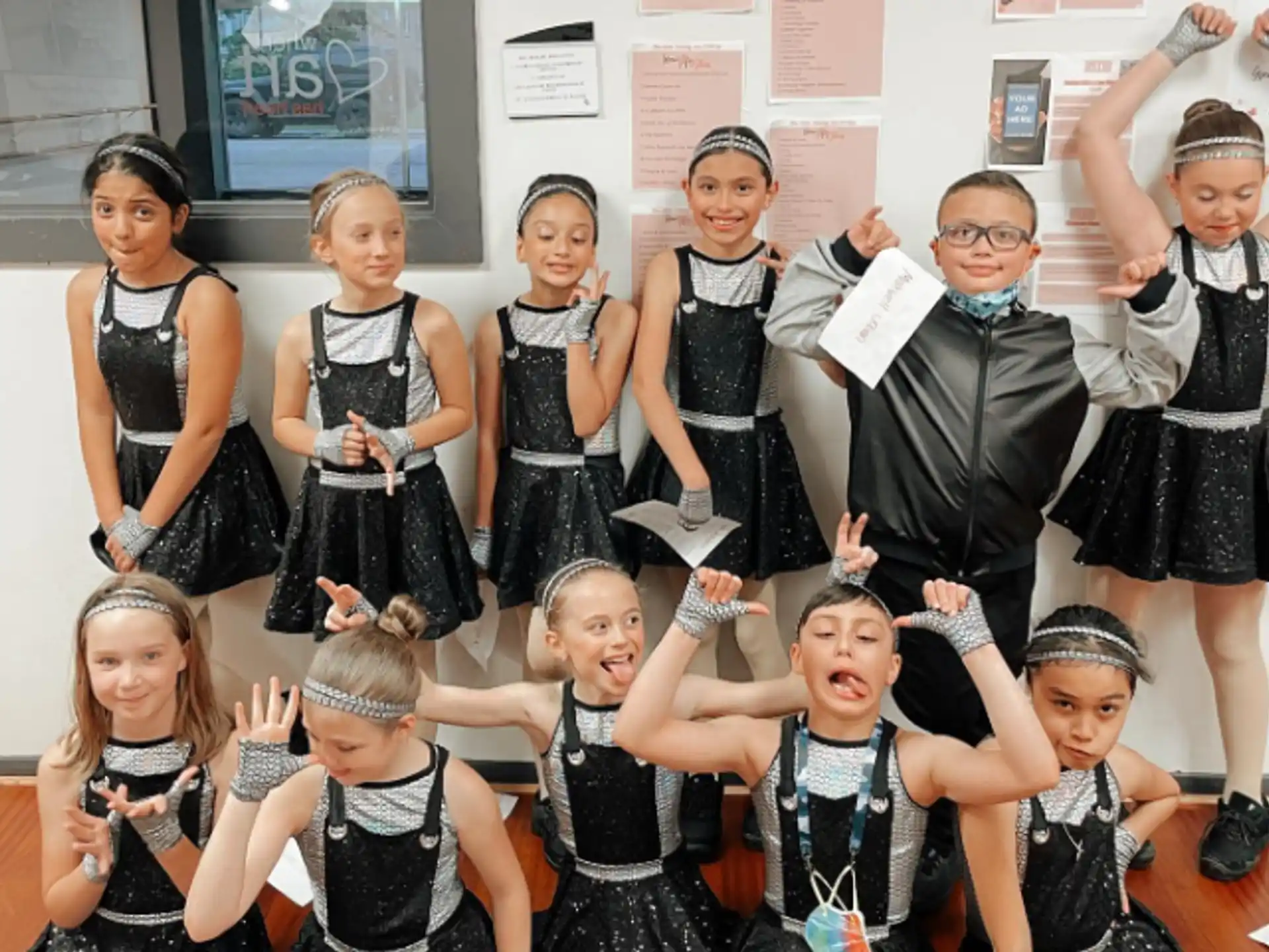 a group of children in black and white dresses