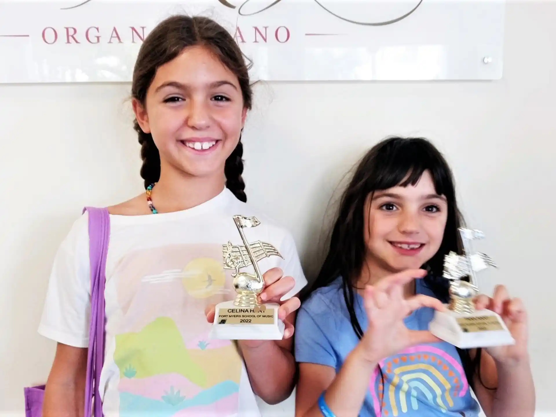 a couple of girls holding trophies