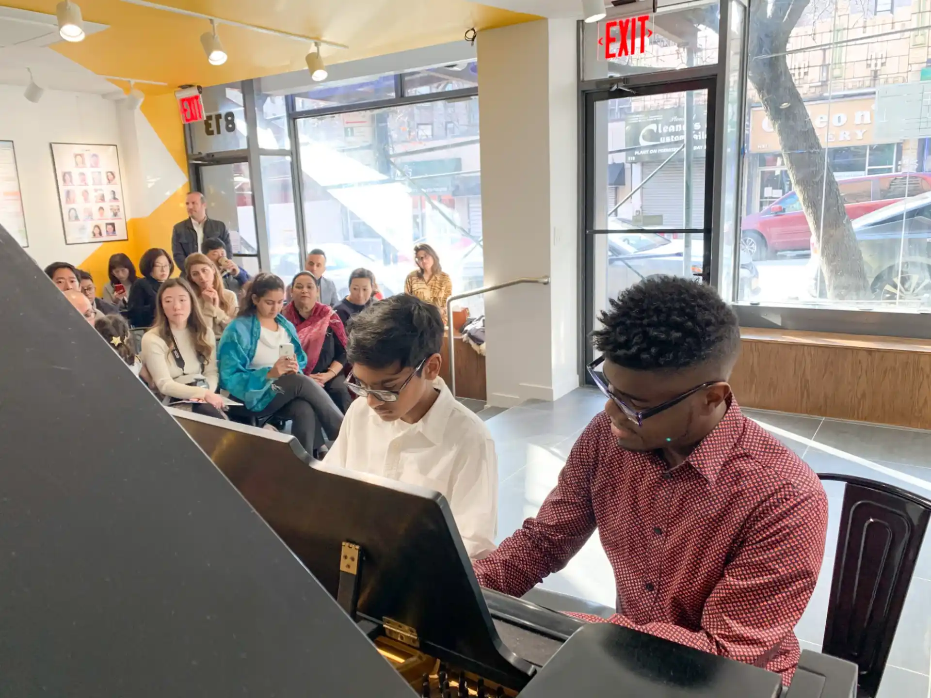 a group of people sitting at a table looking at a laptop