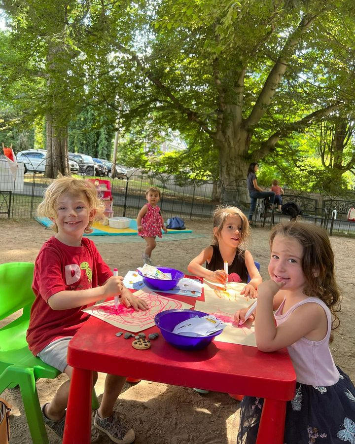 a group of children sitting at a table outside