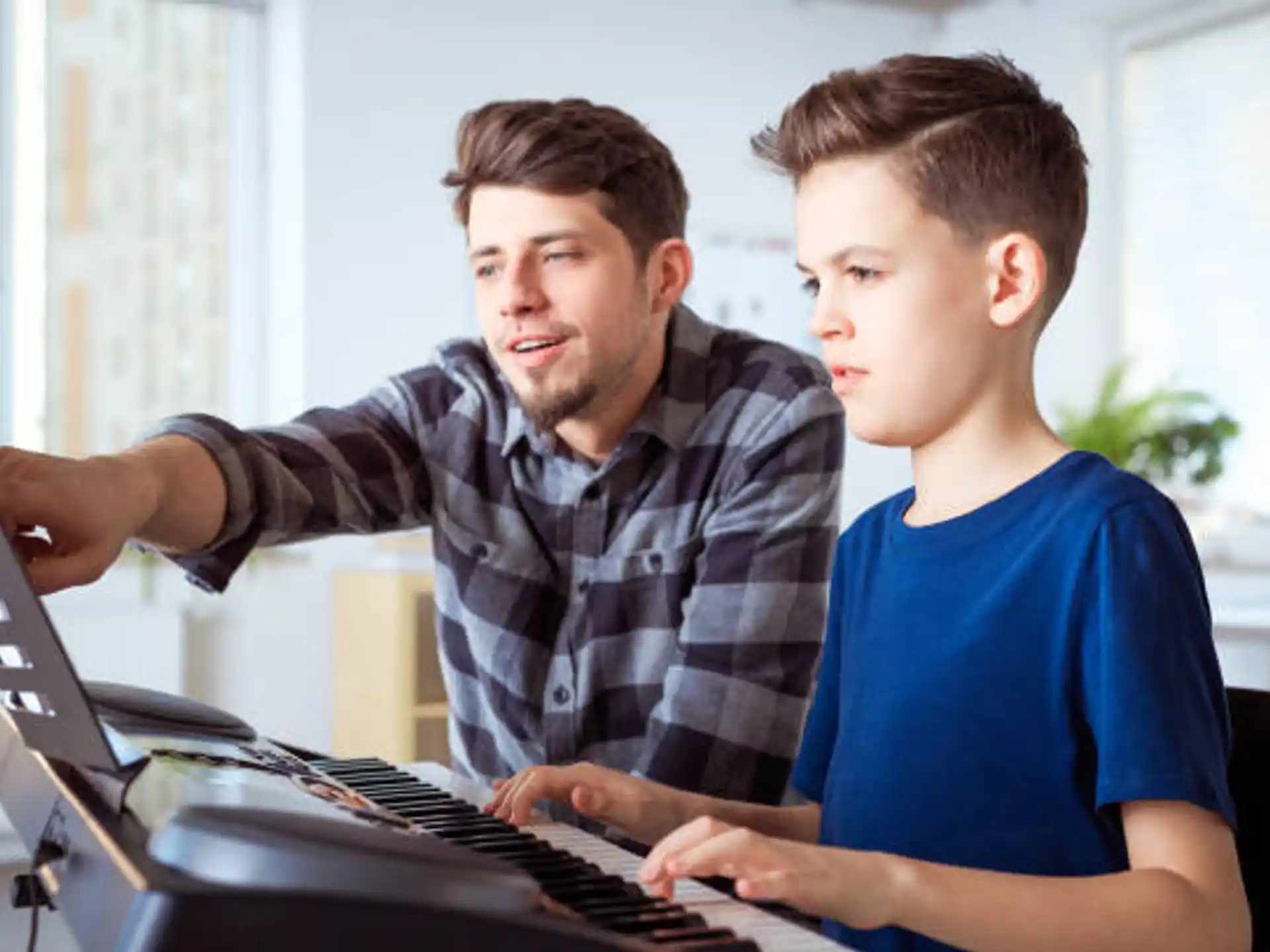a man and a boy playing a piano