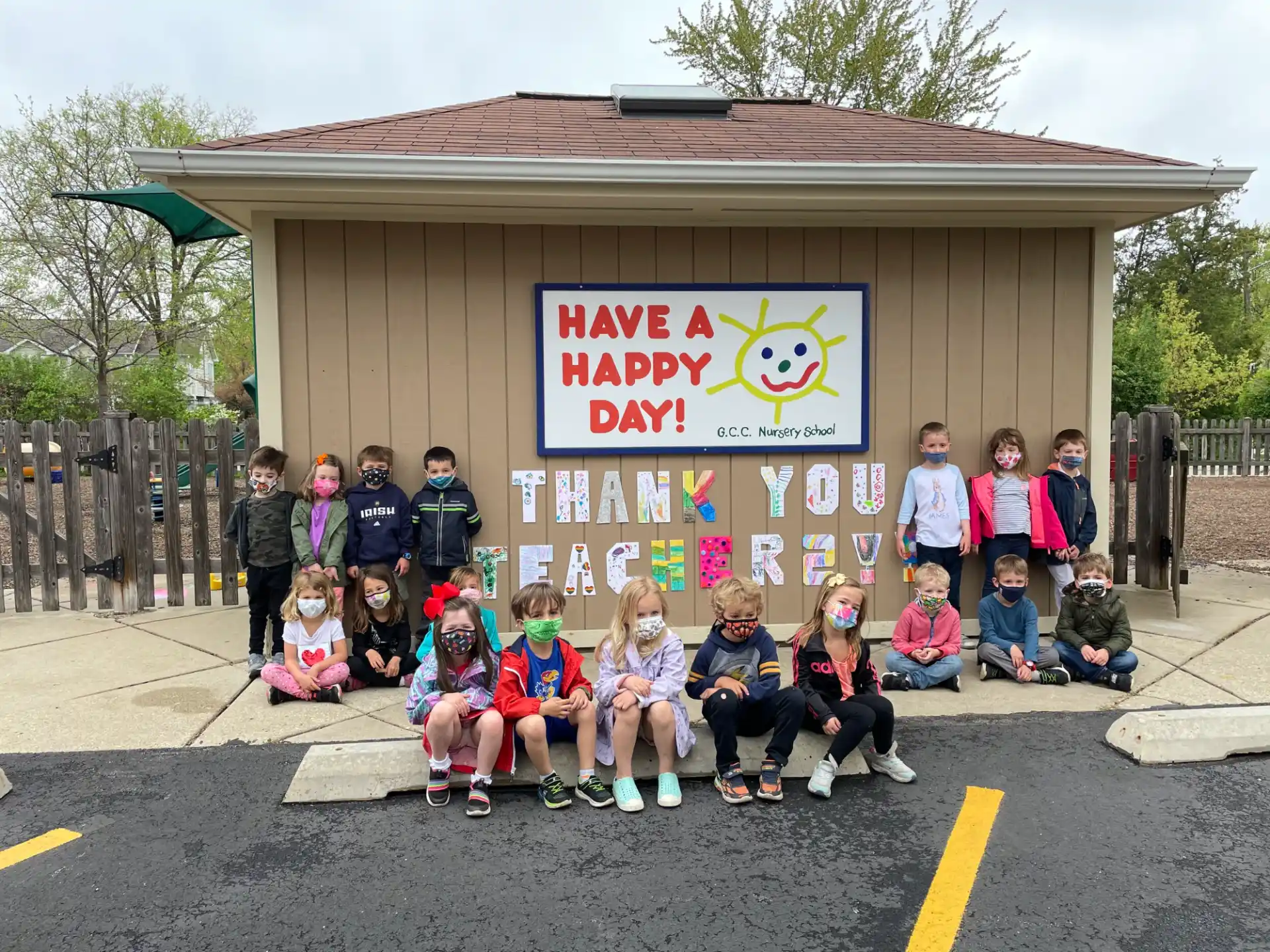 a group of children posing for a photo in front of a building
