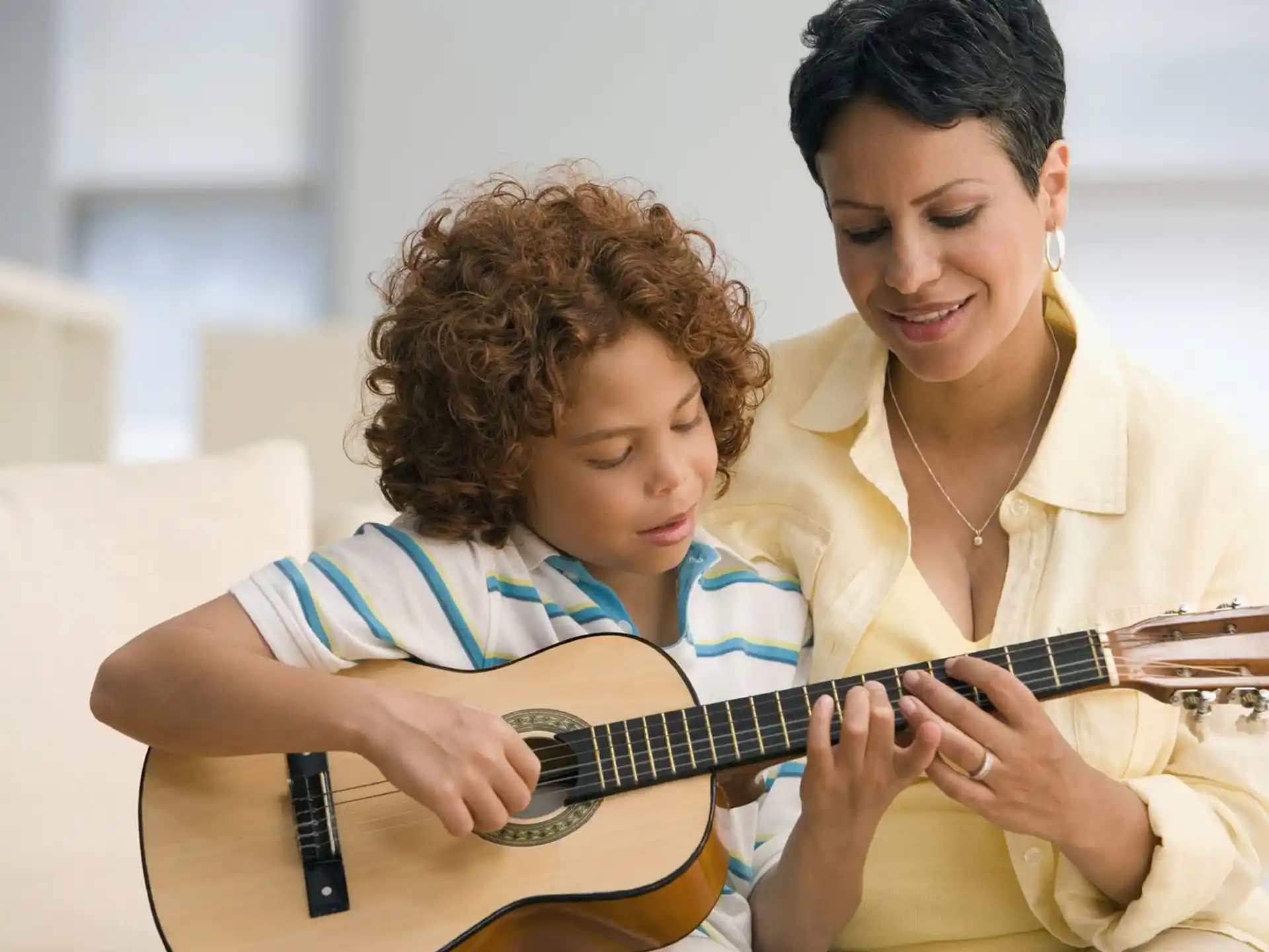 a person playing a guitar next to a person