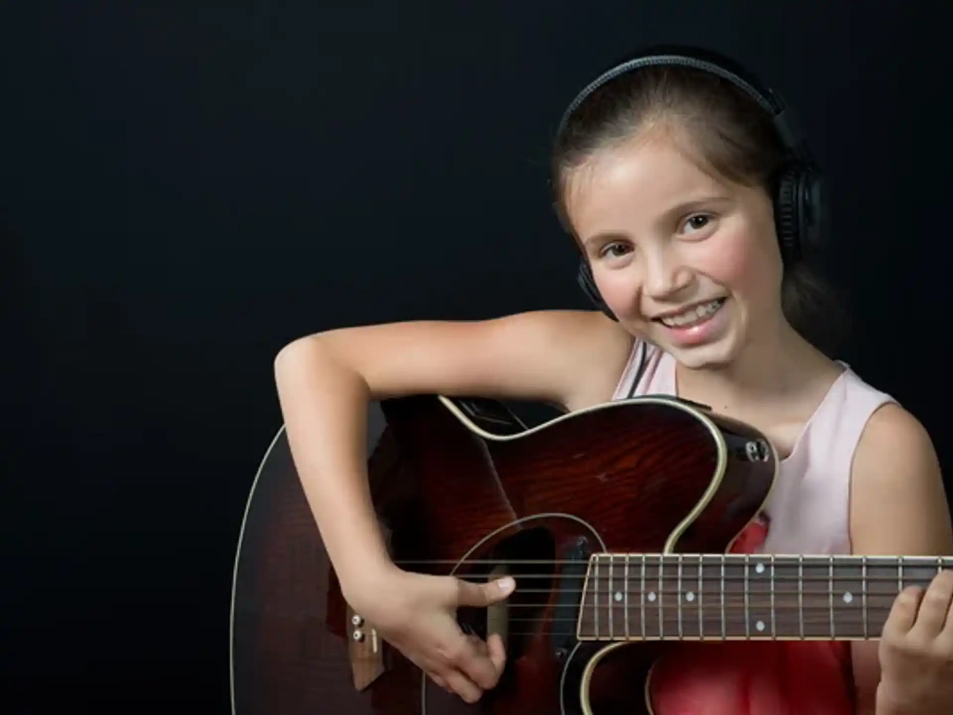 a young girl playing a guitar