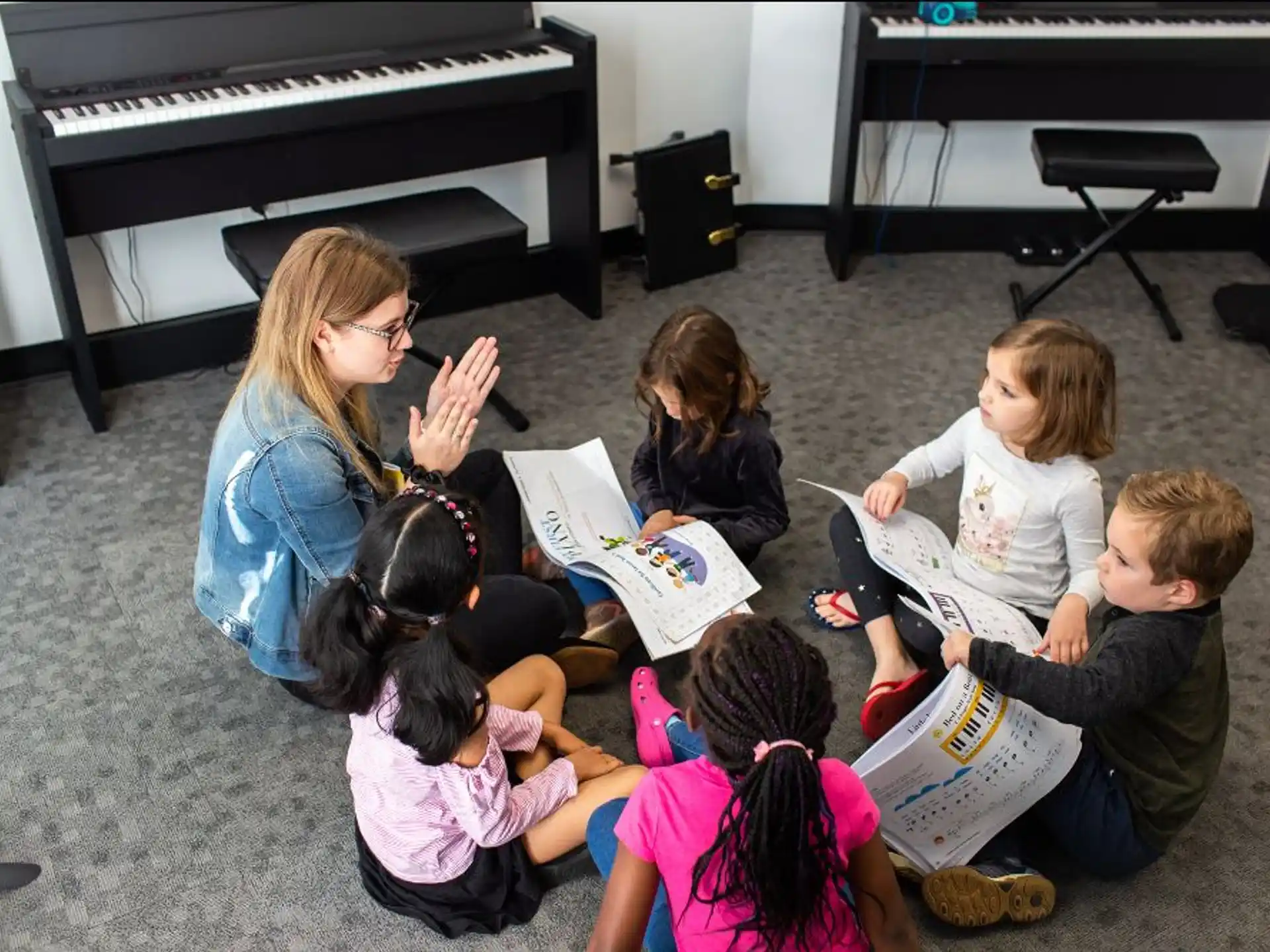 a group of children sitting on the floor reading a book