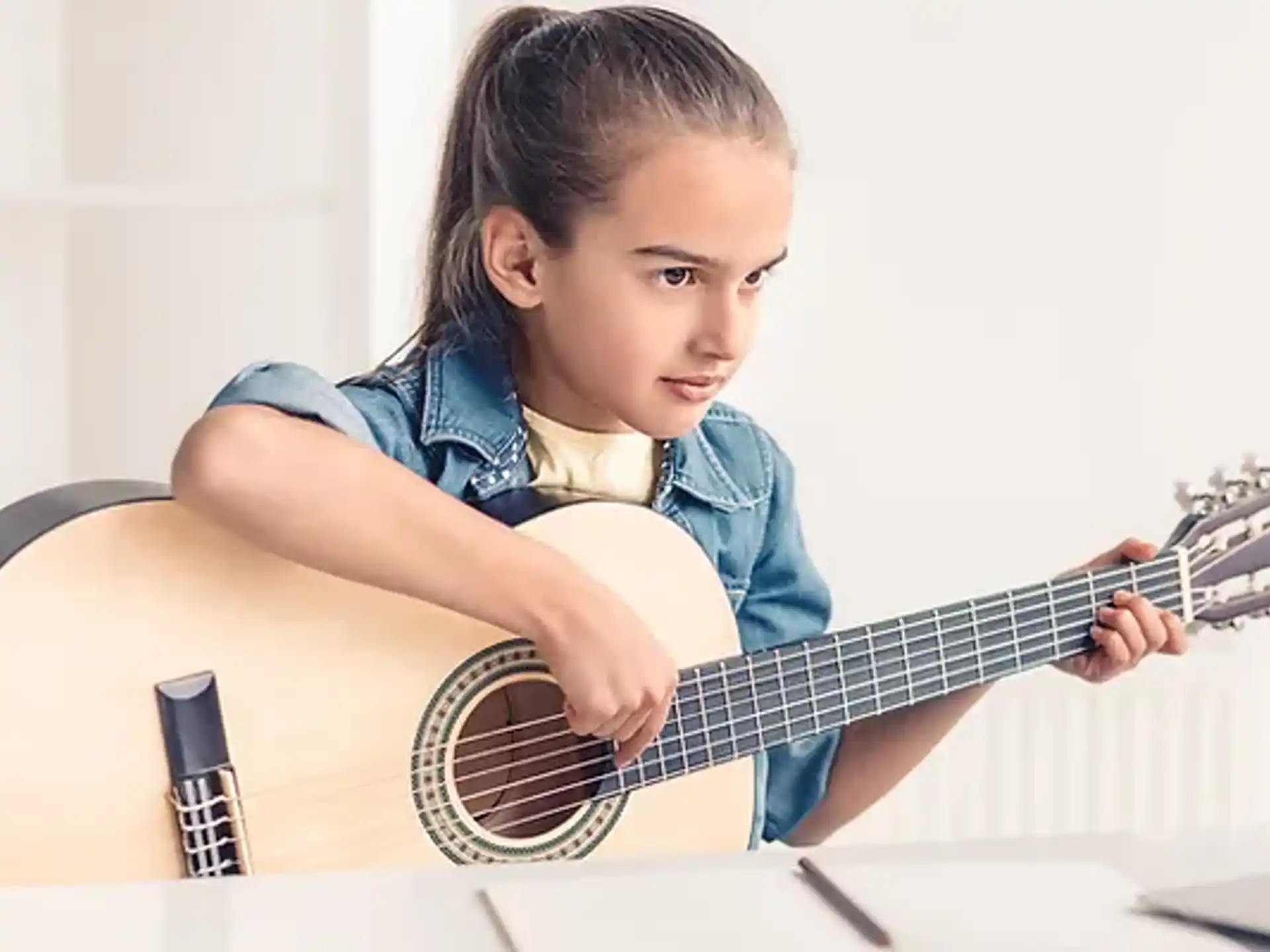 a young girl playing a guitar