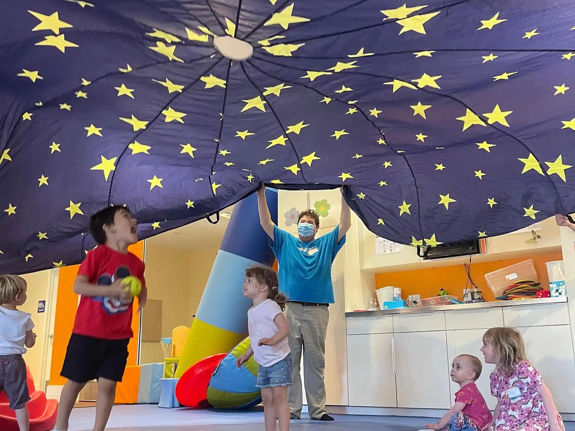 a person and children playing on a stage