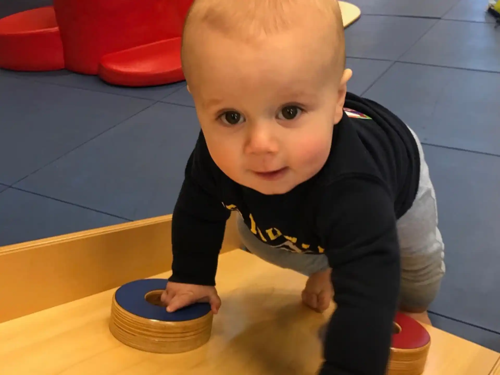 a baby standing on a wood floor