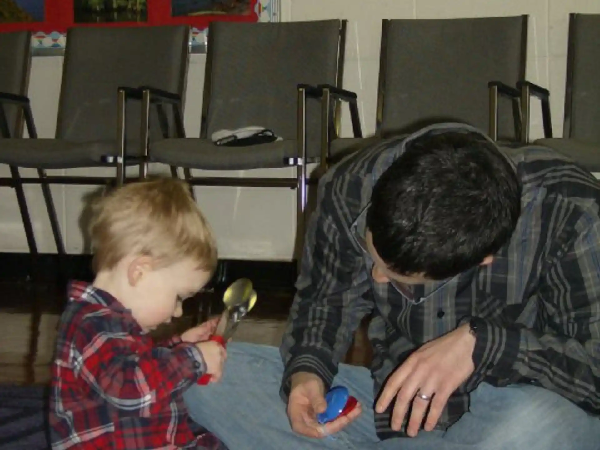 a person and a boy playing with toys on the floor