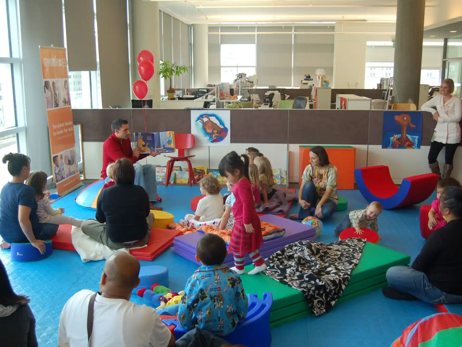a group of people sitting on the floor with balloons