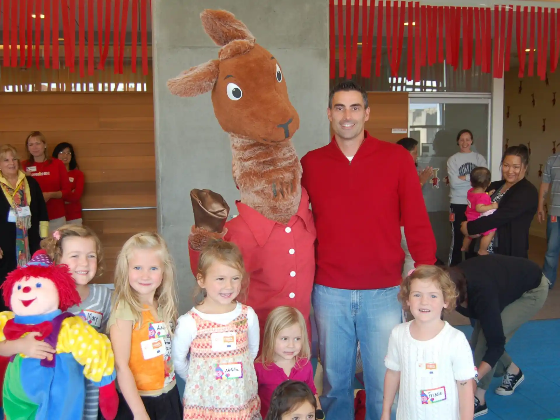 a man and a group of children posing with a person in a garment