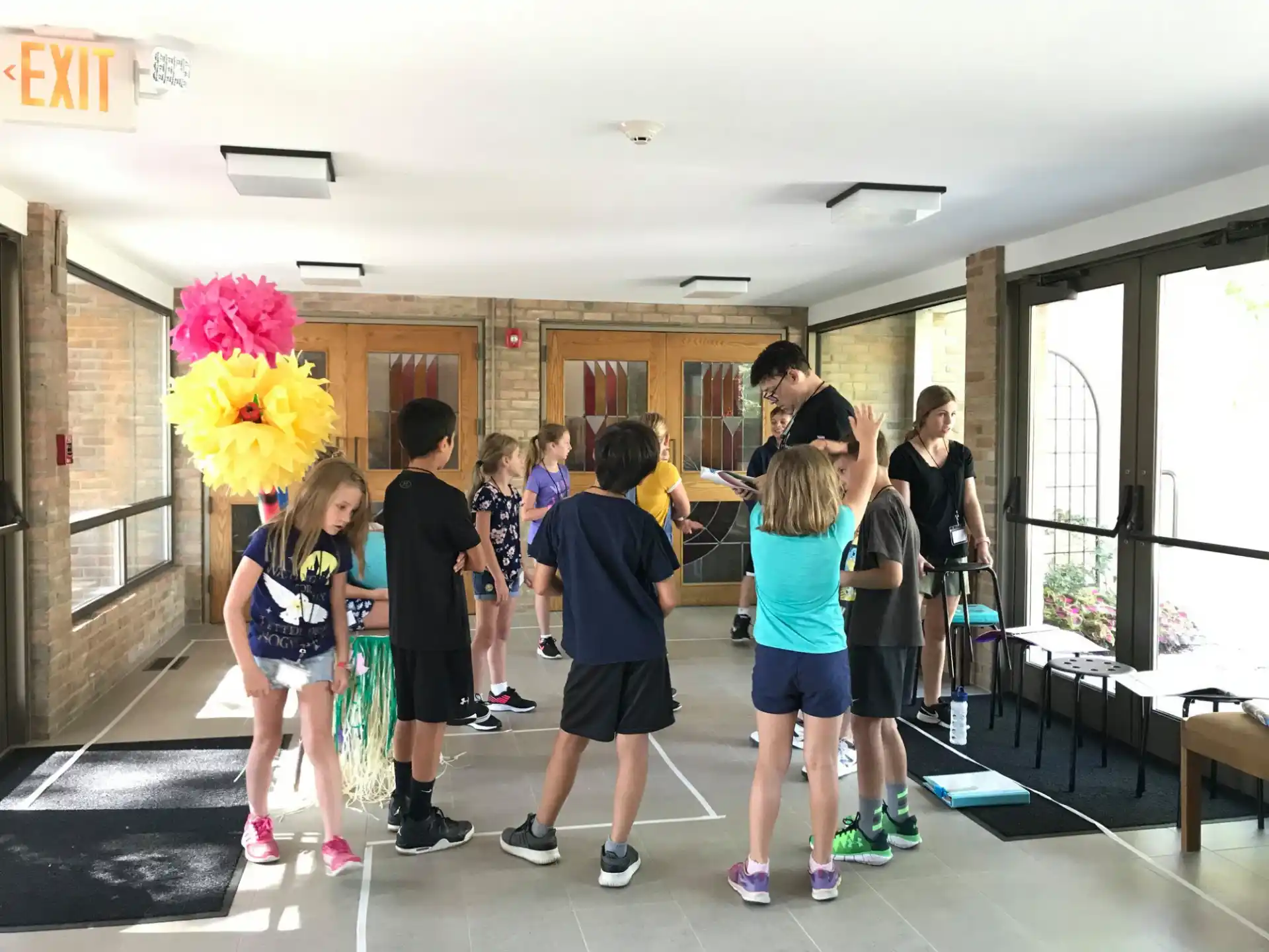 a group of people standing in a room with a large flower