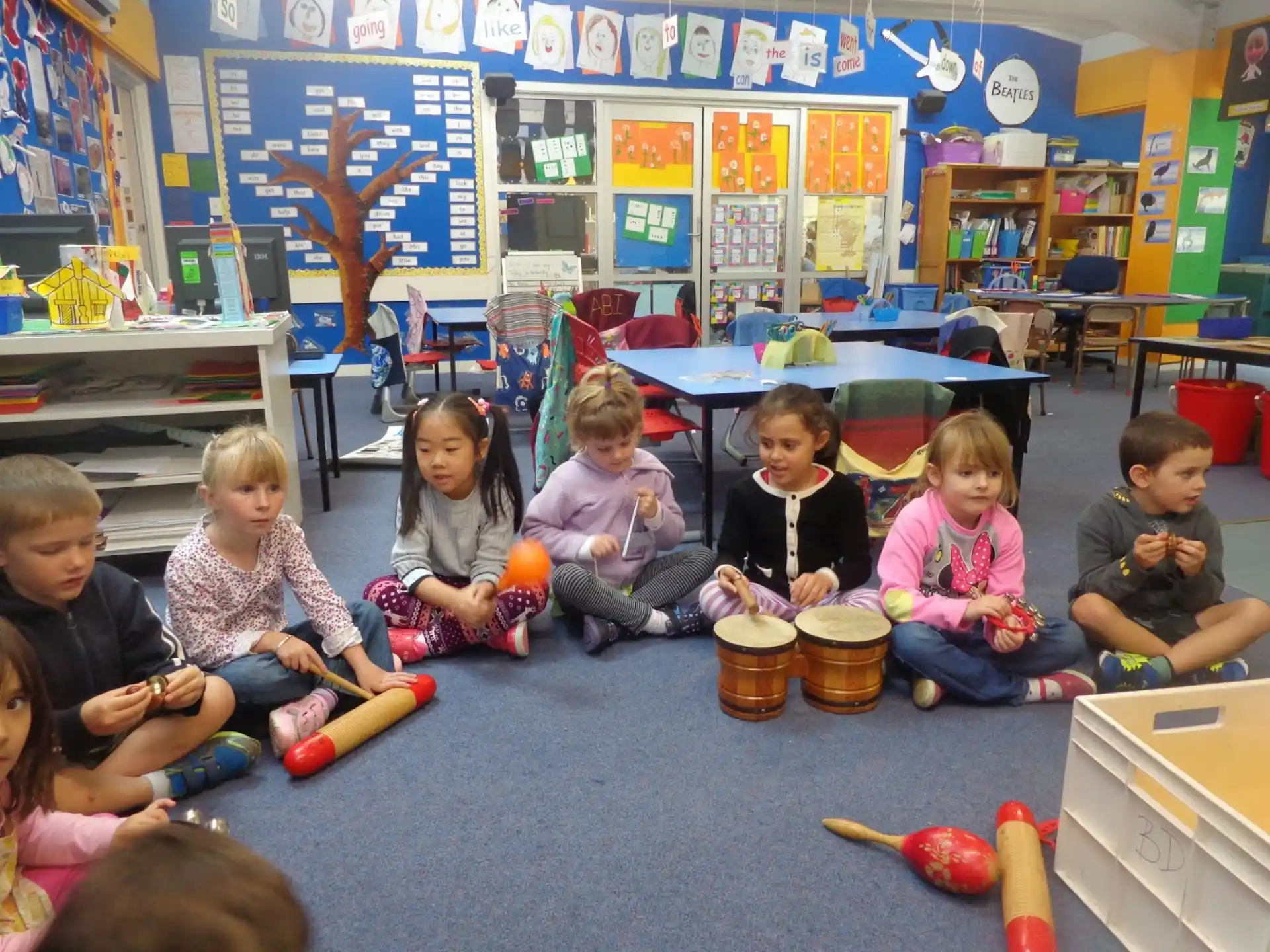 a group of children sitting on the floor in a classroom