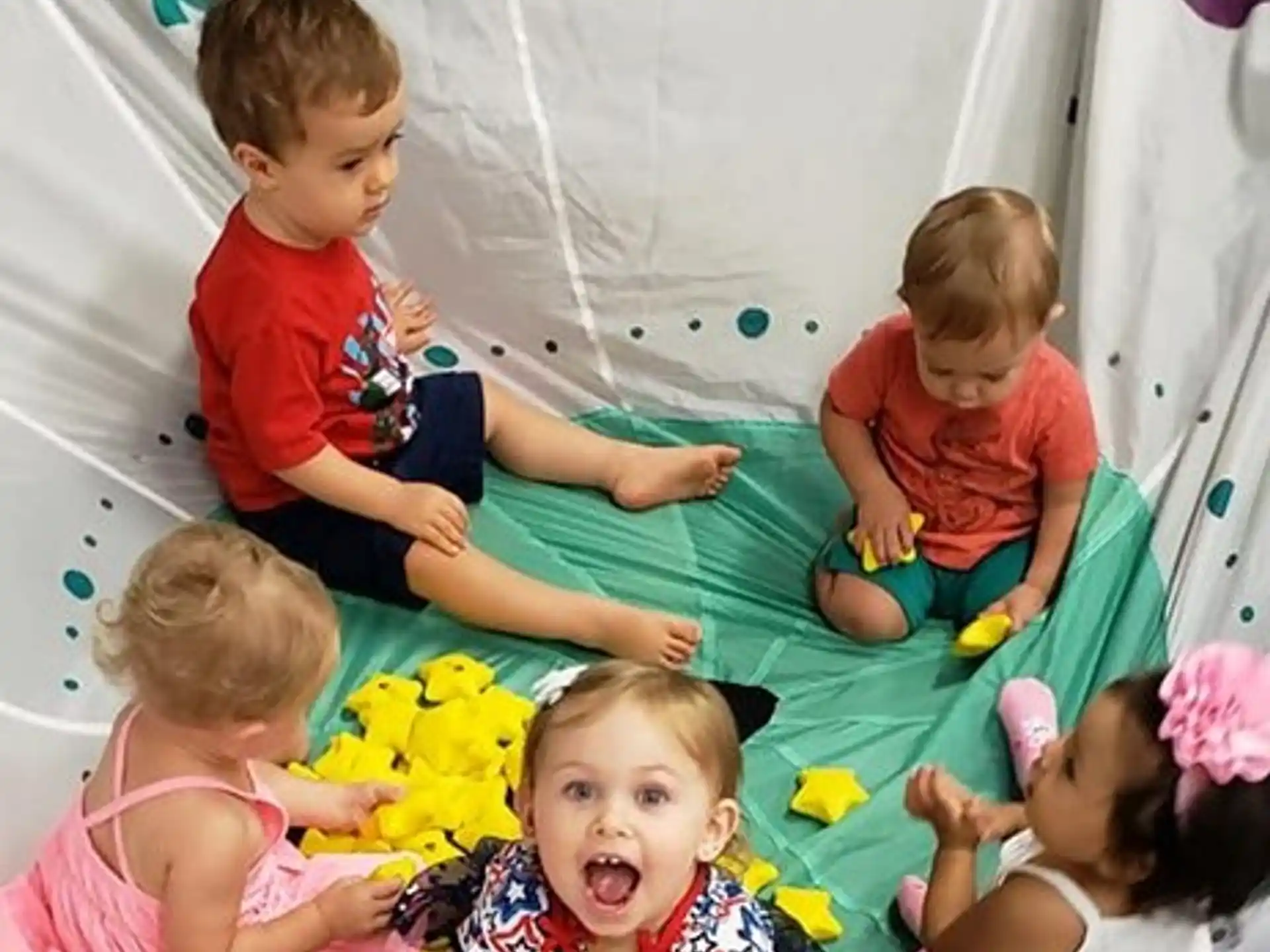 a group of children sitting on a bed