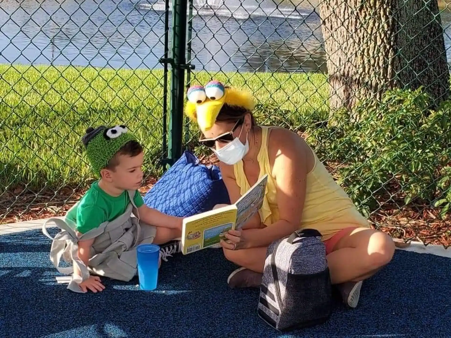 a person and two children sitting on a bench with a person in a mask and a mask