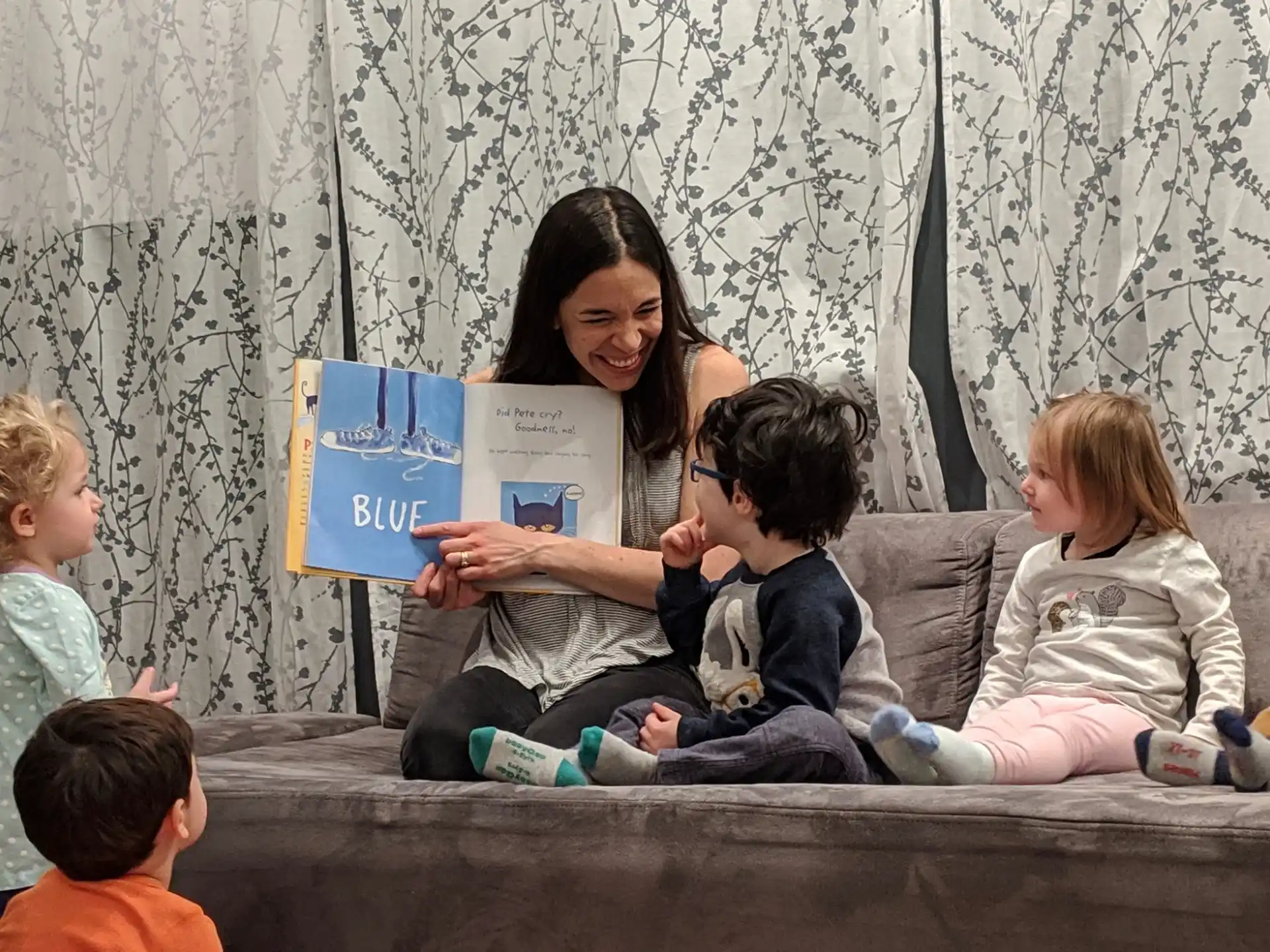 a person reading a book to a group of children