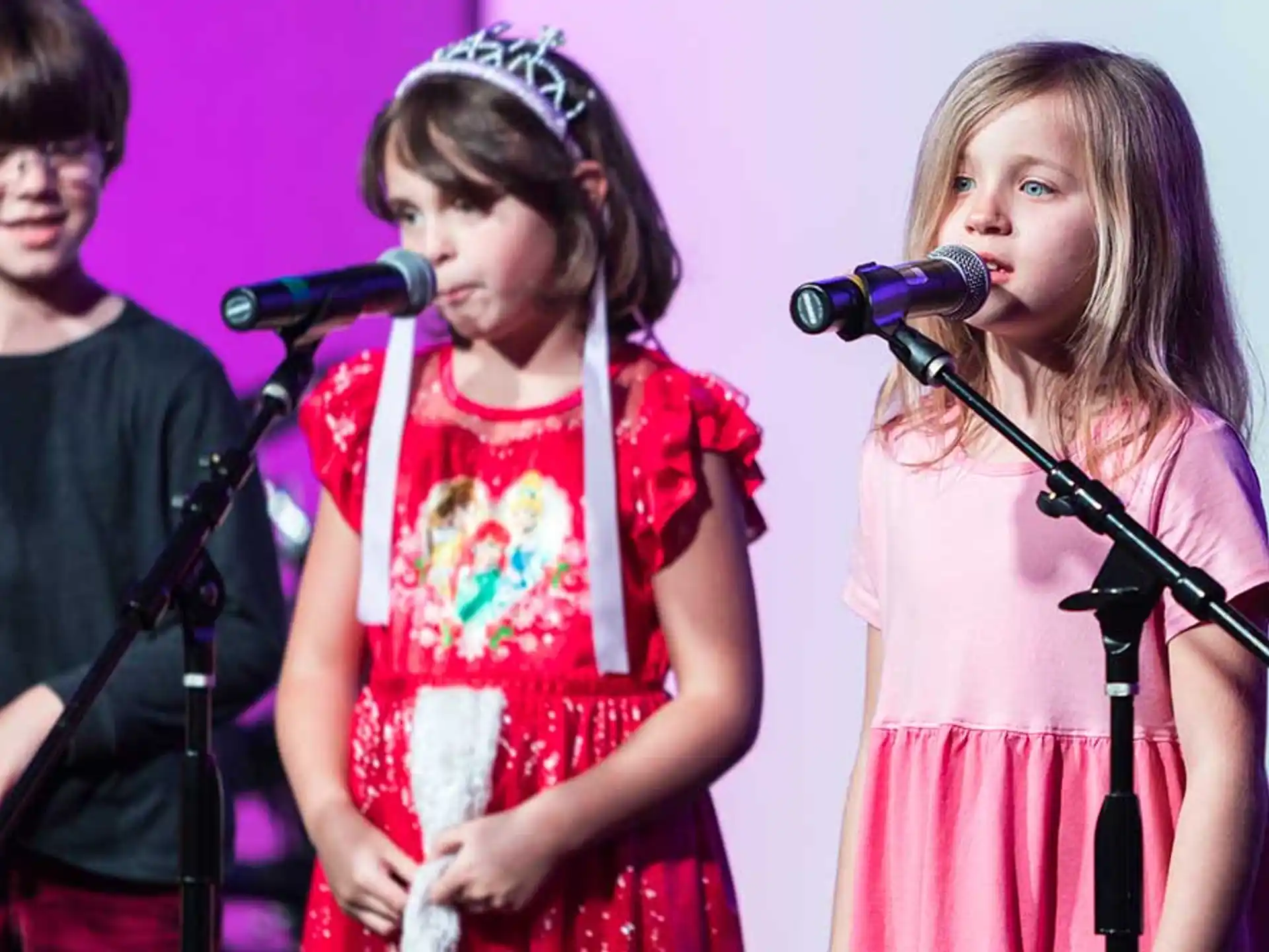 a group of people singing into microphones