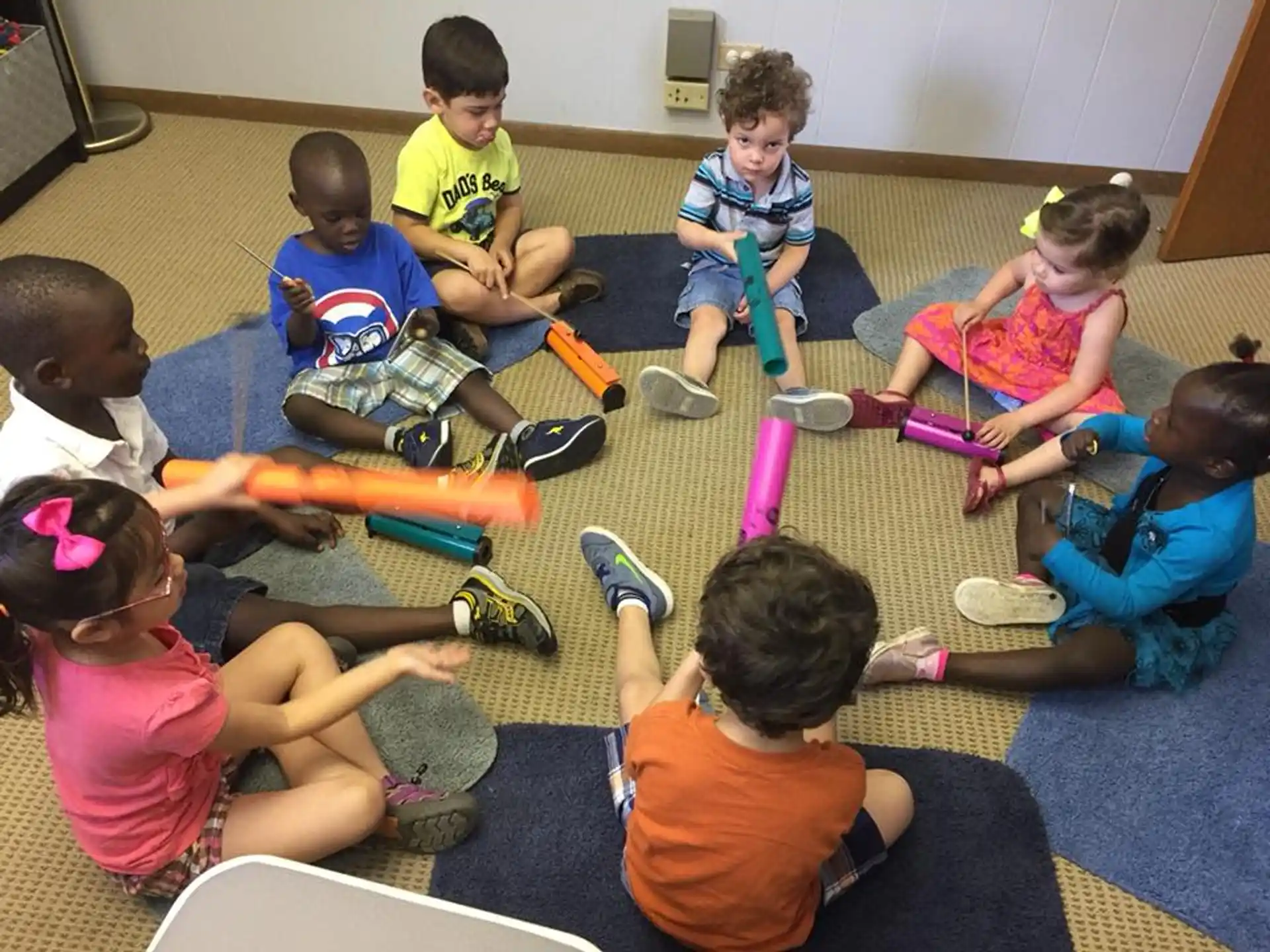a group of children sitting on the floor playing with toys