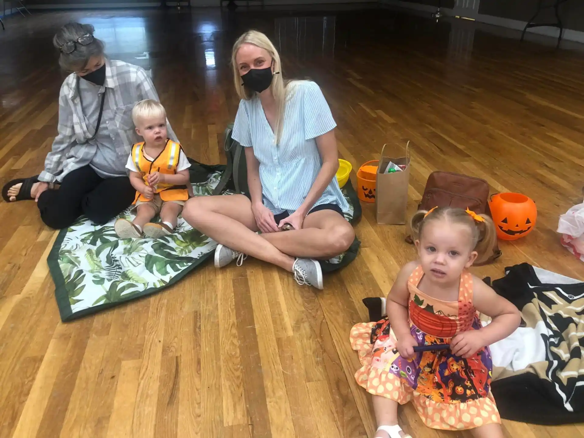 a group of people sitting on the floor with toys