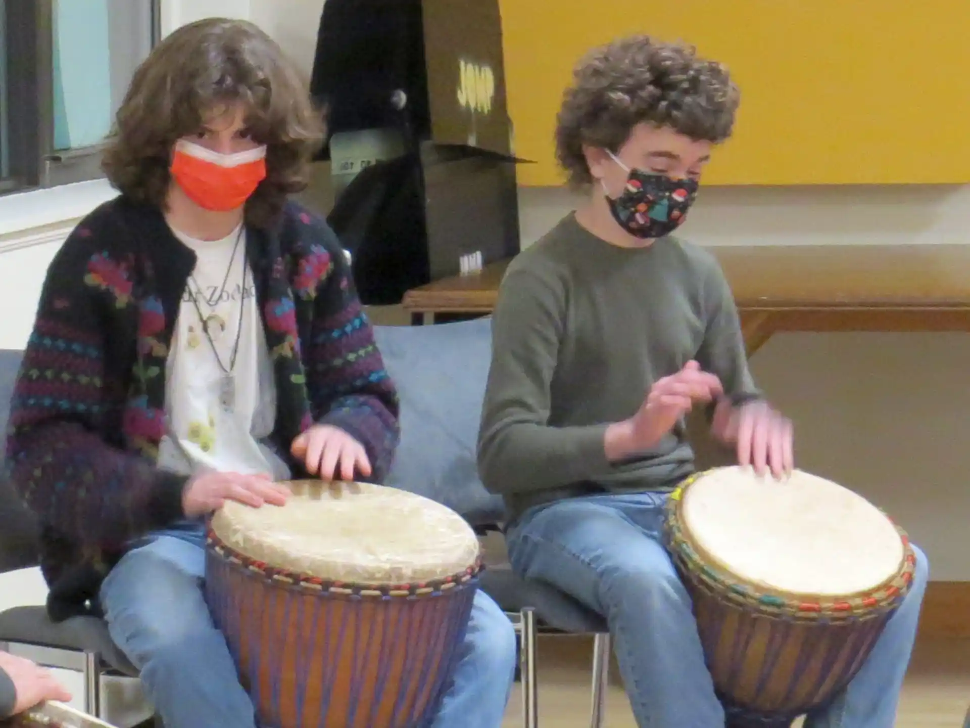 a couple of people wearing masks and playing drums