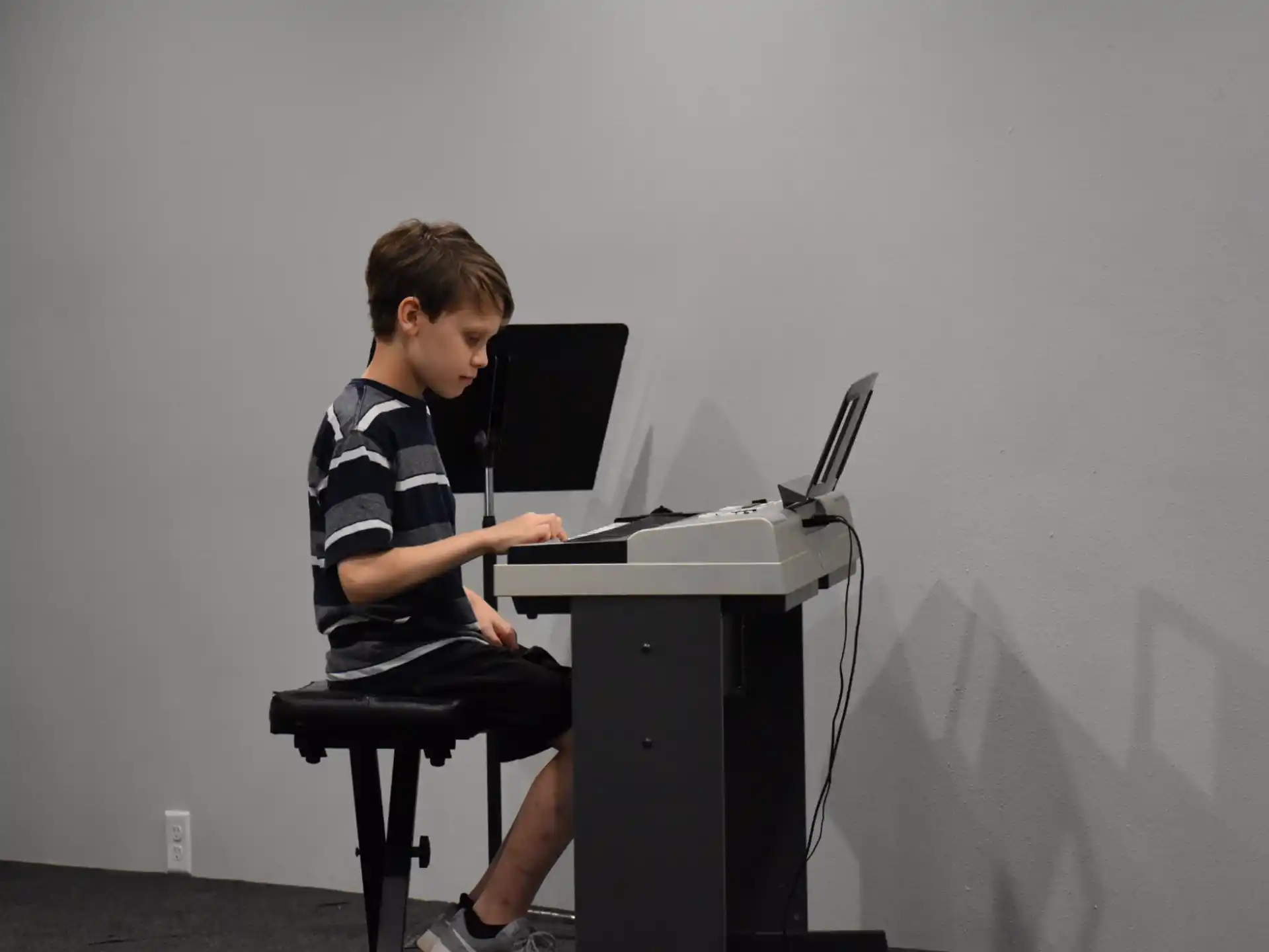 a boy sitting at a desk with a laptop