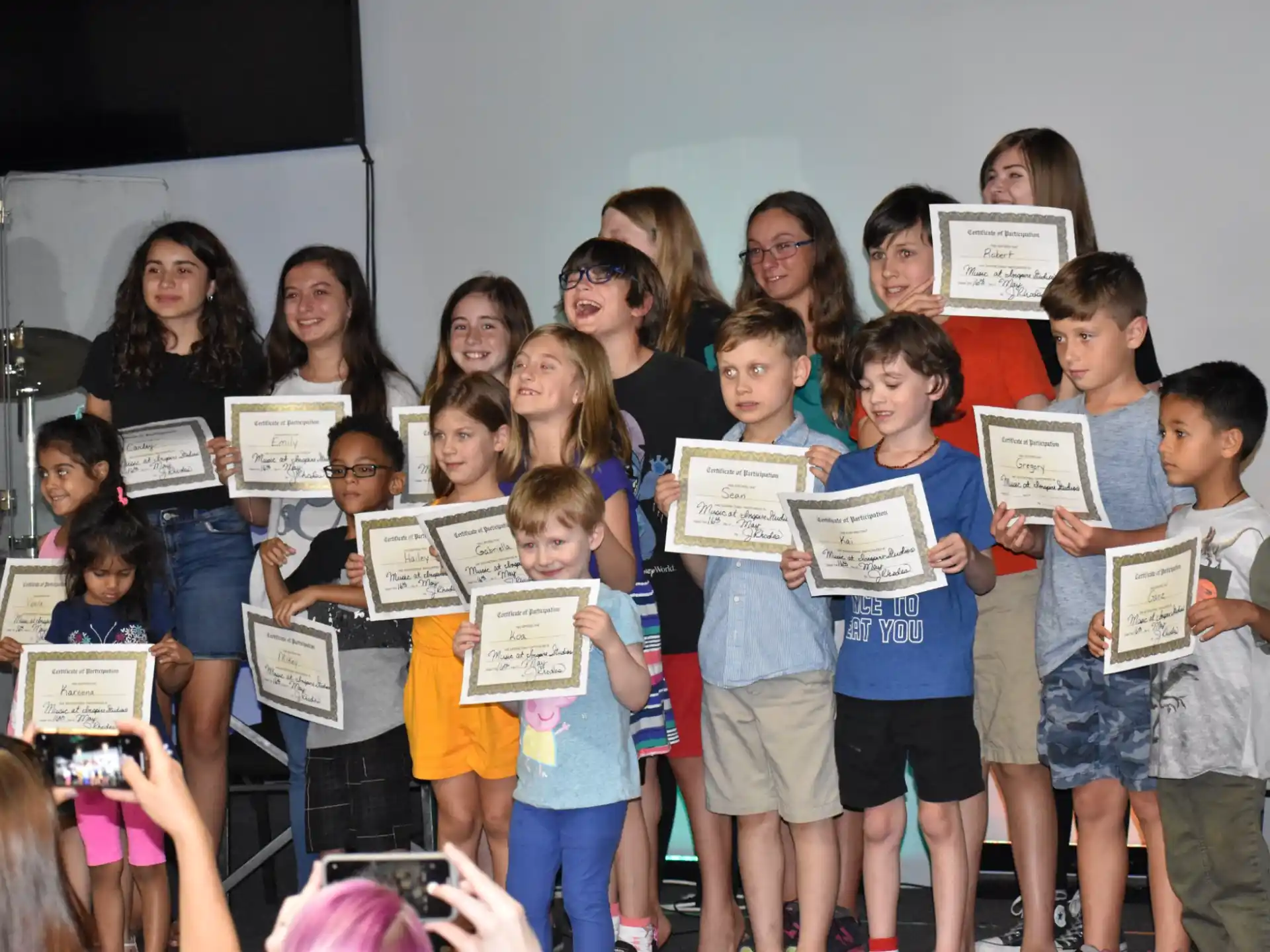 a group of children holding certificates