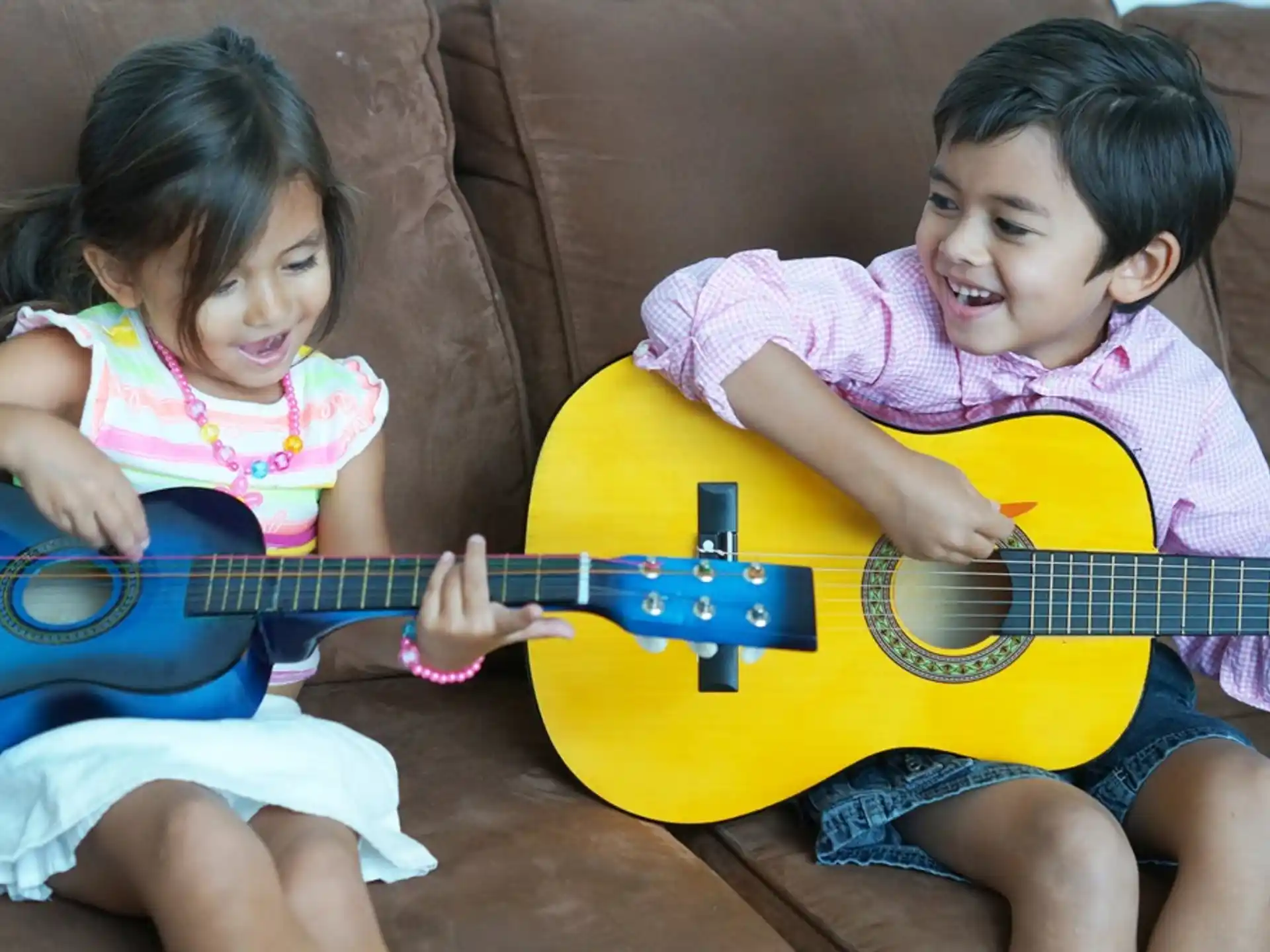 a couple of children playing a guitar