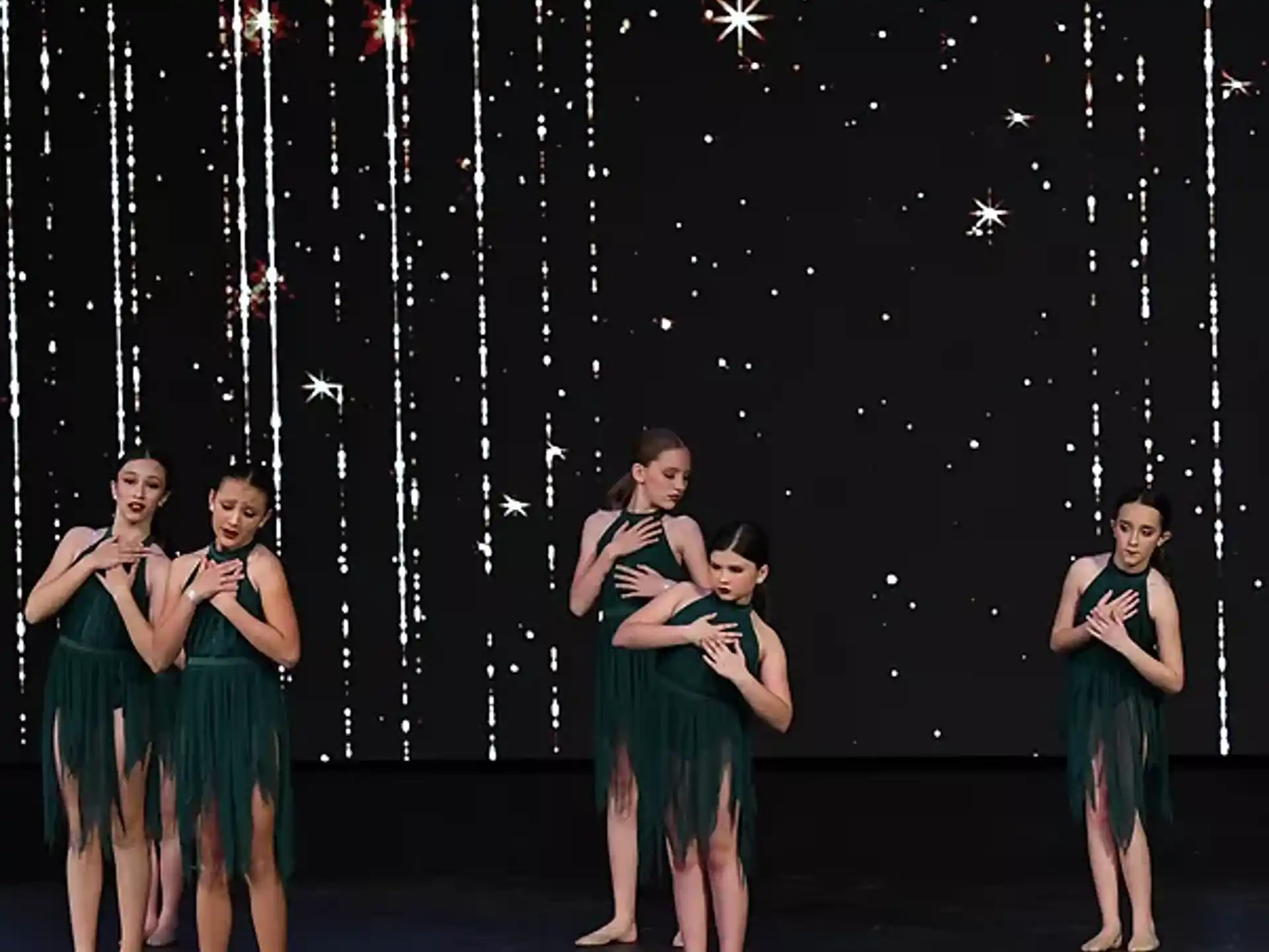a group of women in green dresses on a stage