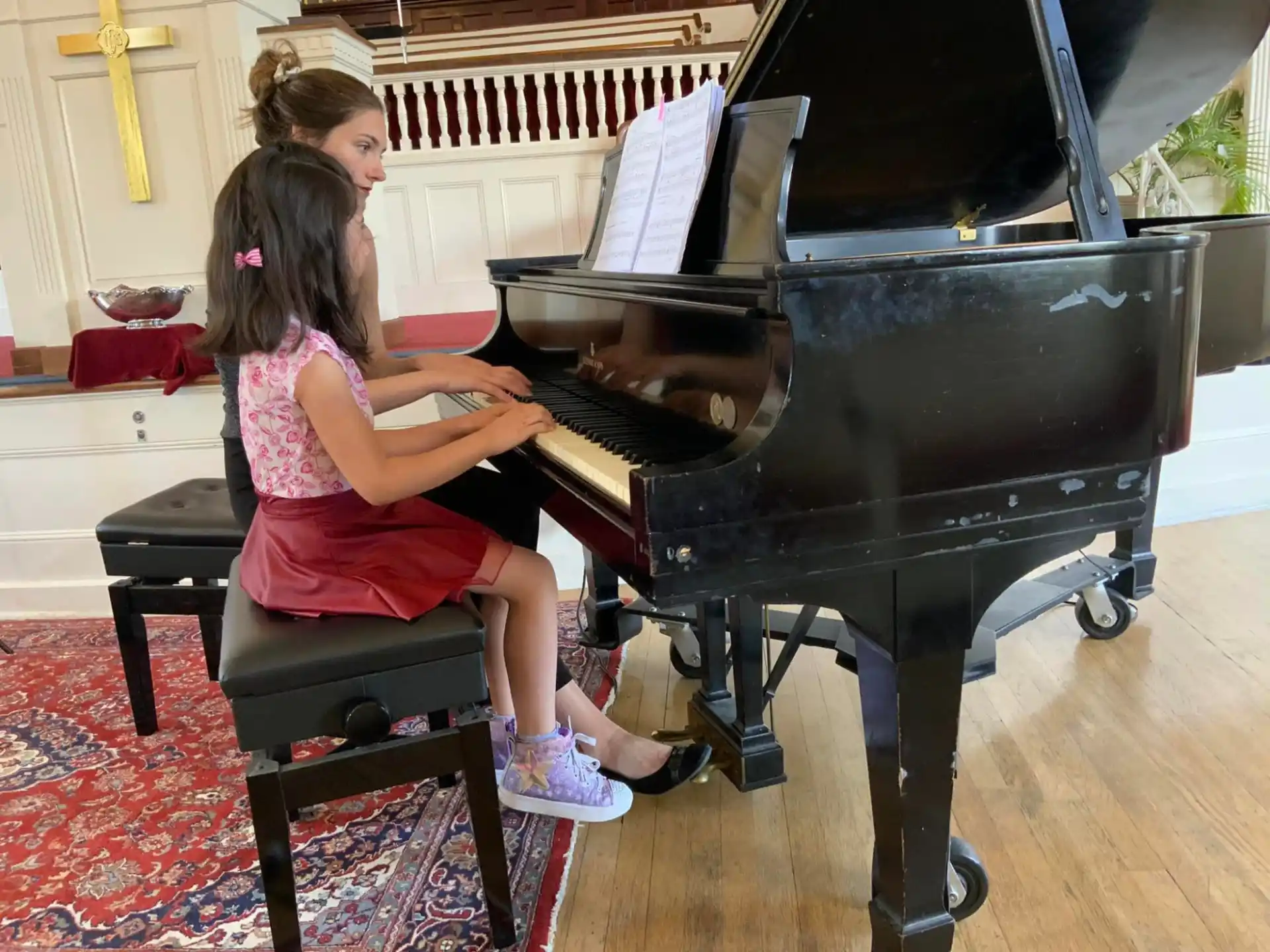 a couple of girls playing piano
