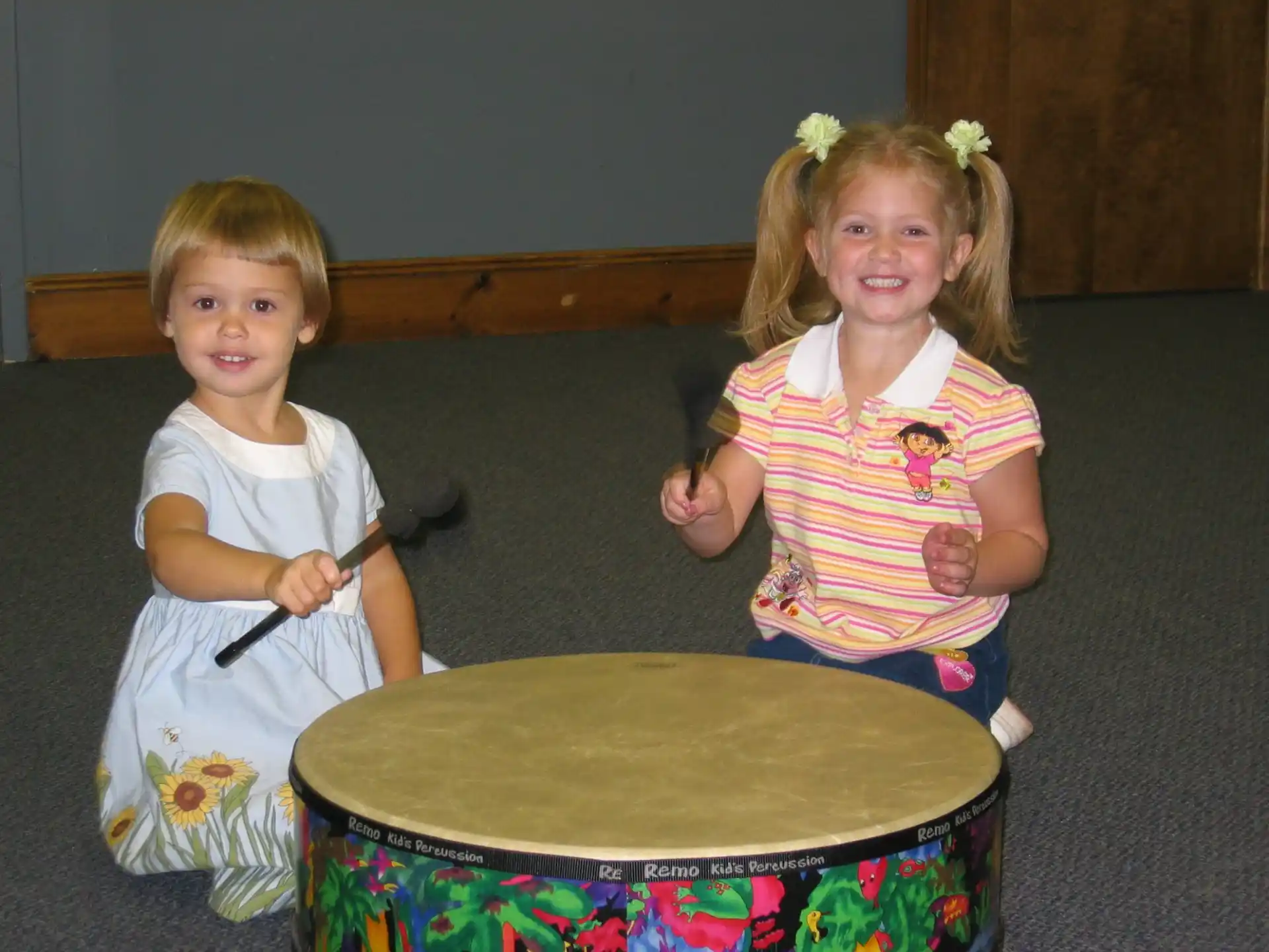 a couple of children playing with a bucket of water